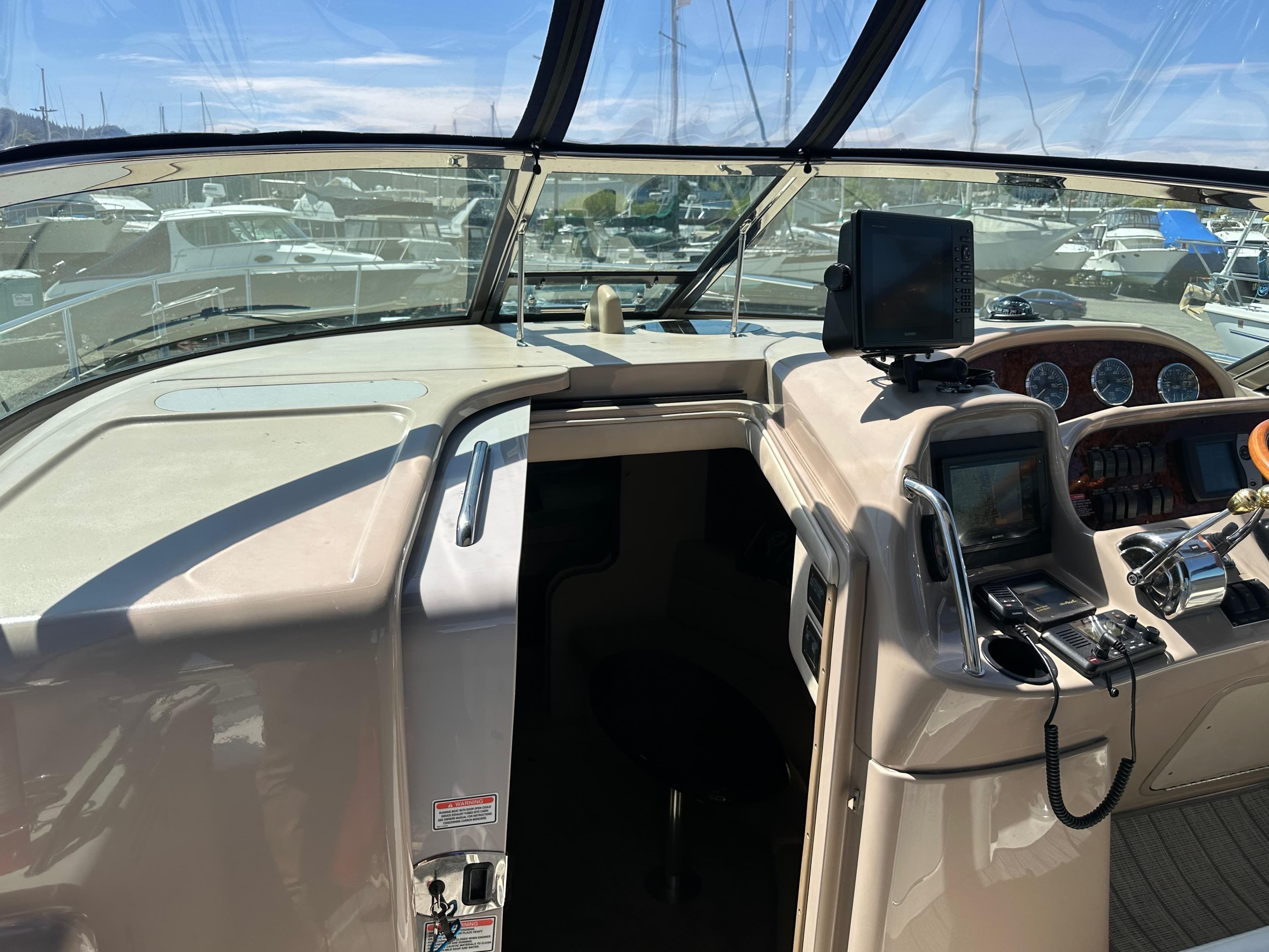 2004 Sea Ray 360 Sundancer helm with navigation equipment and marina view.