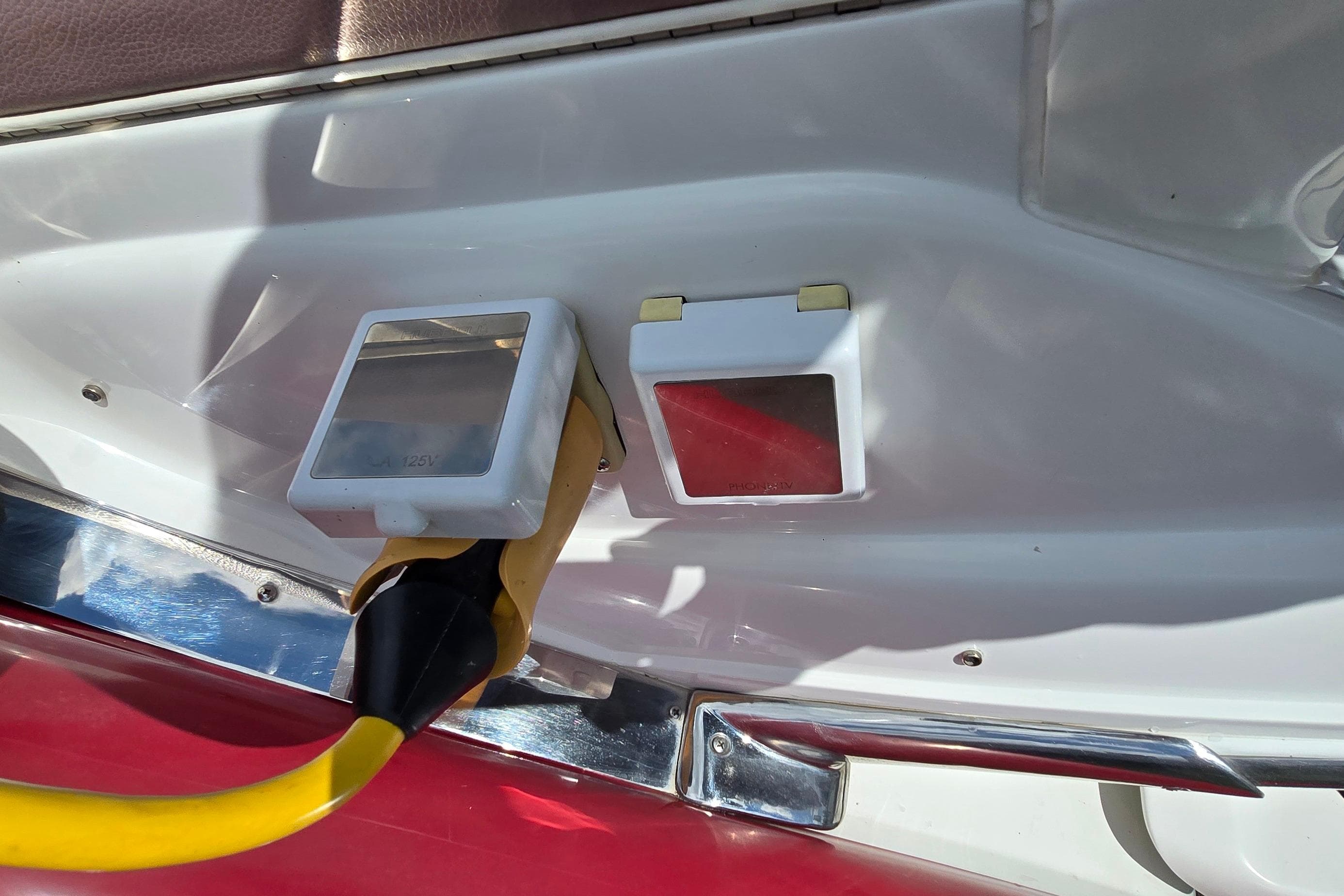 Power outlet on a 2011 Cobalt 323 boat with yellow cable connected.