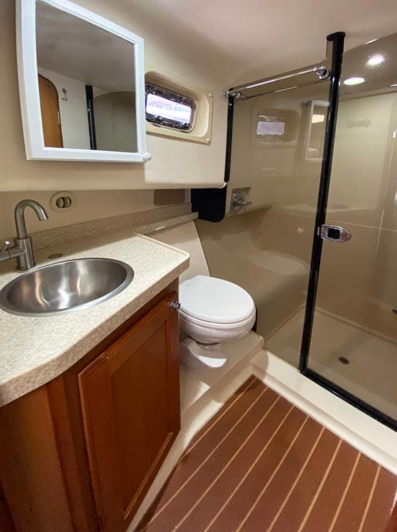 Bathroom interior of a 2004 Mainship 340 yacht with sink, toilet, and shower.