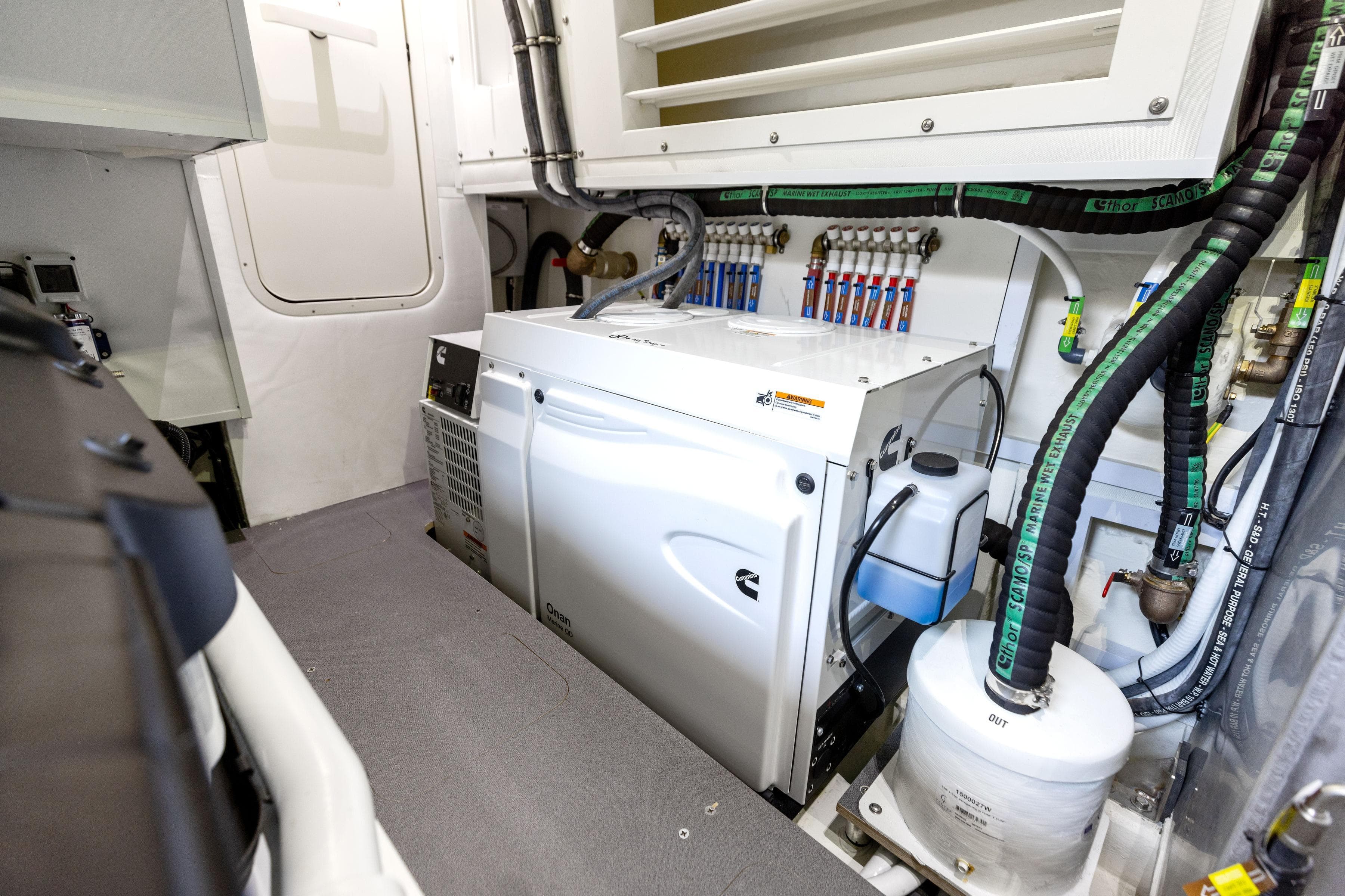 Engine room of 2024 Absolute Navetta 64 yacht with Cummins generator and piping system.