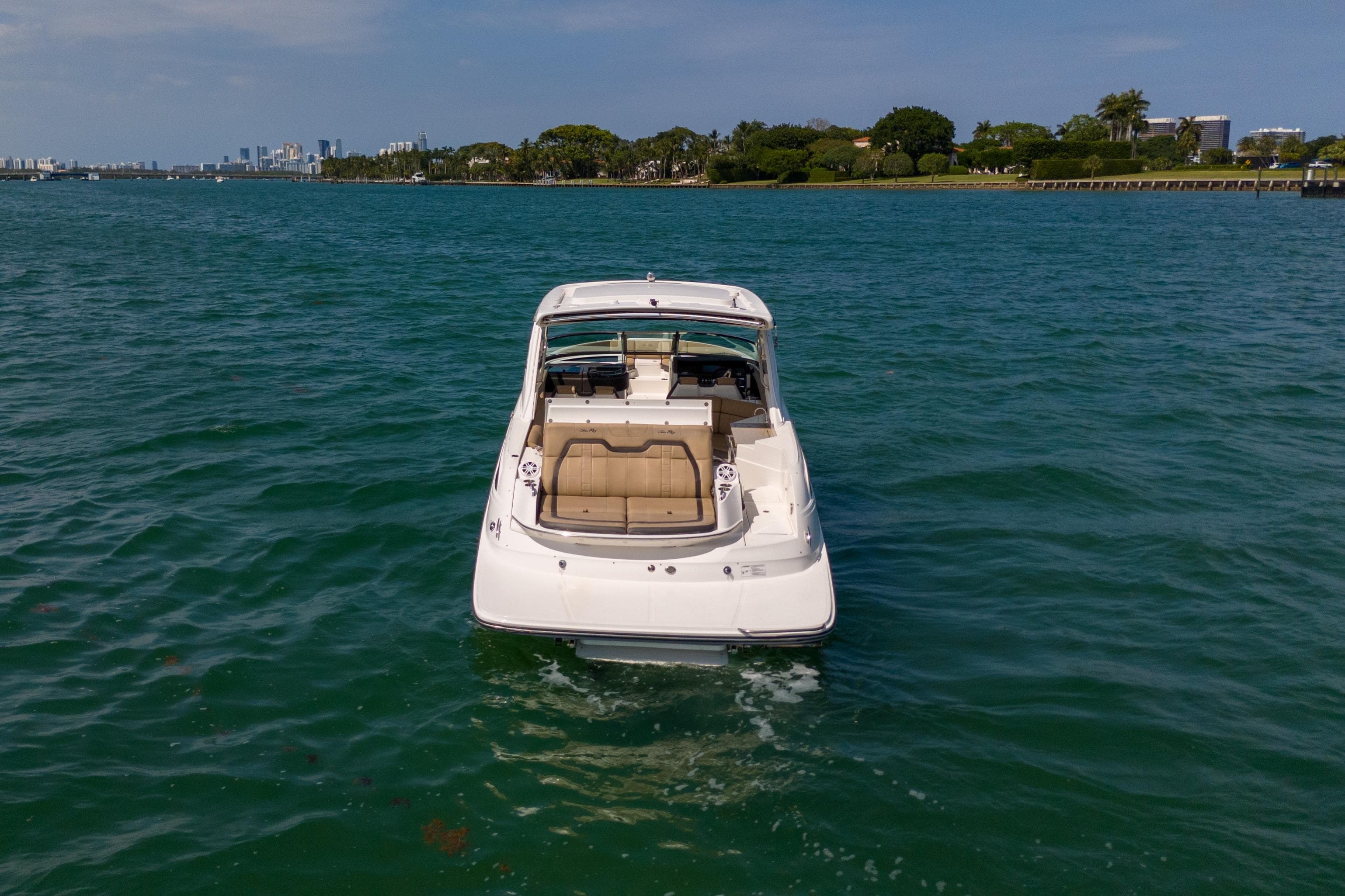 2016 Sea Ray SLX 350 boat on calm water with city skyline in background.