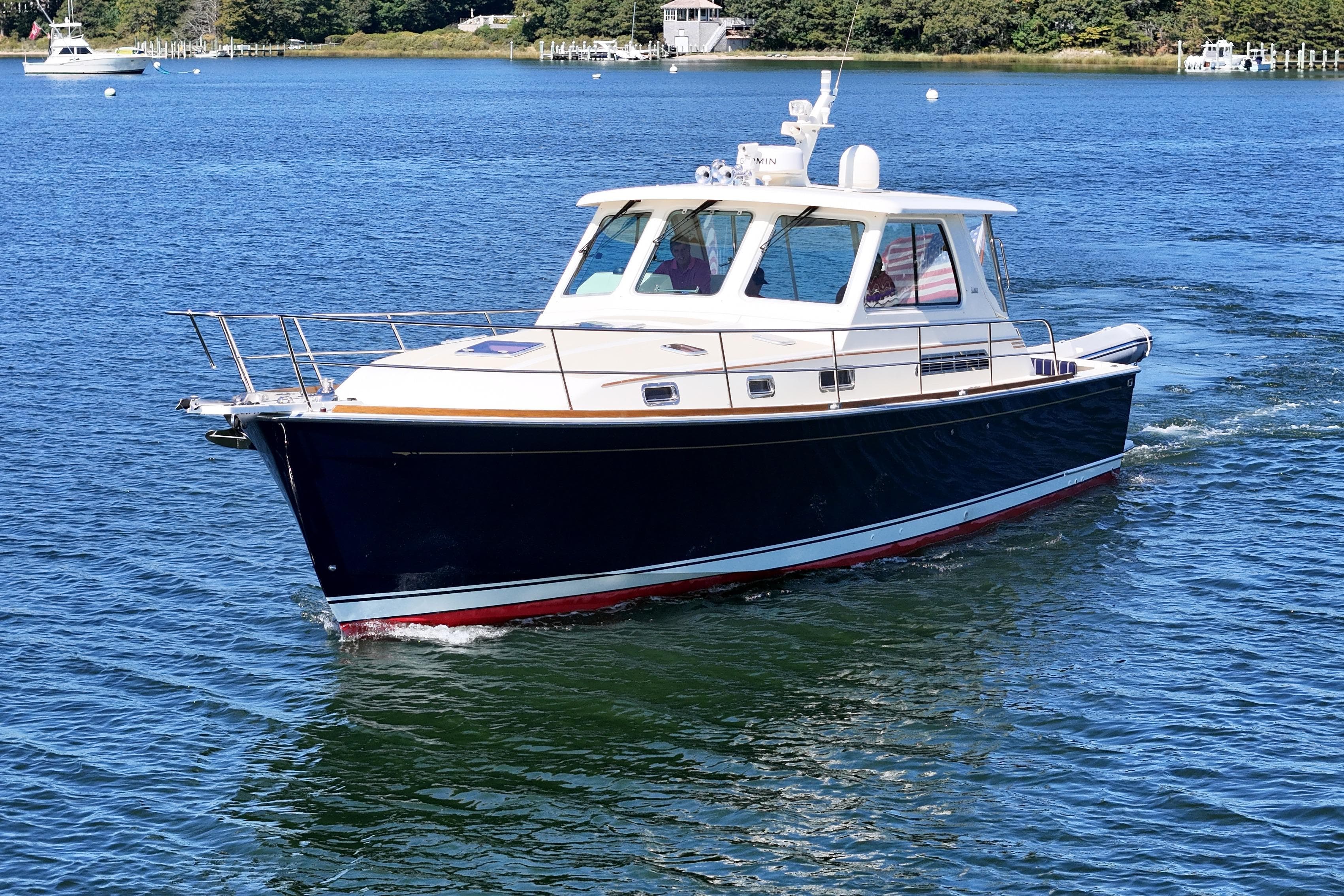 2009 Sabre 42 Express yacht cruising on a serene blue lake.