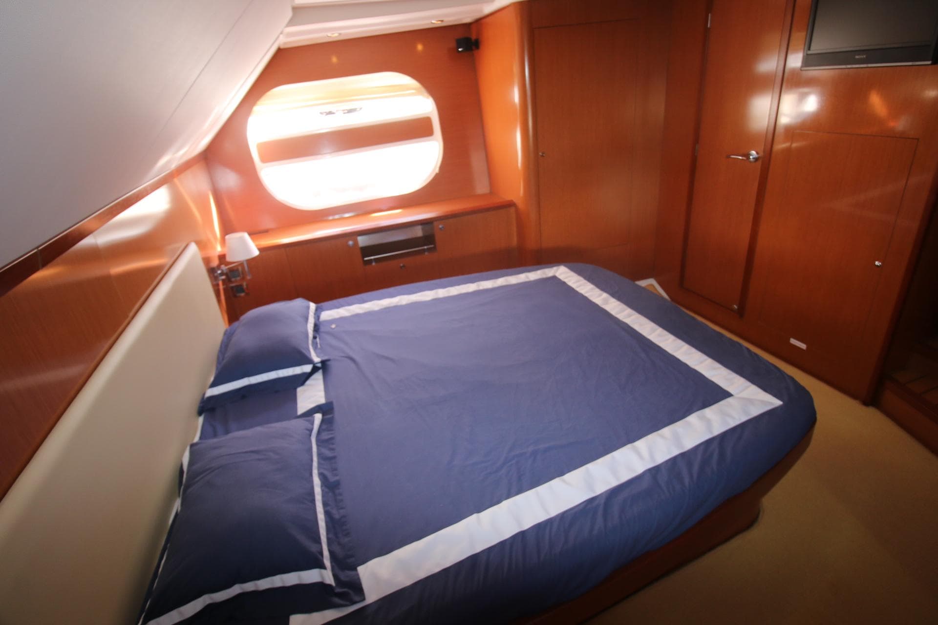 Luxurious cabin interior of 2008 Beneteau Swift Trawler 52 with blue bedding.