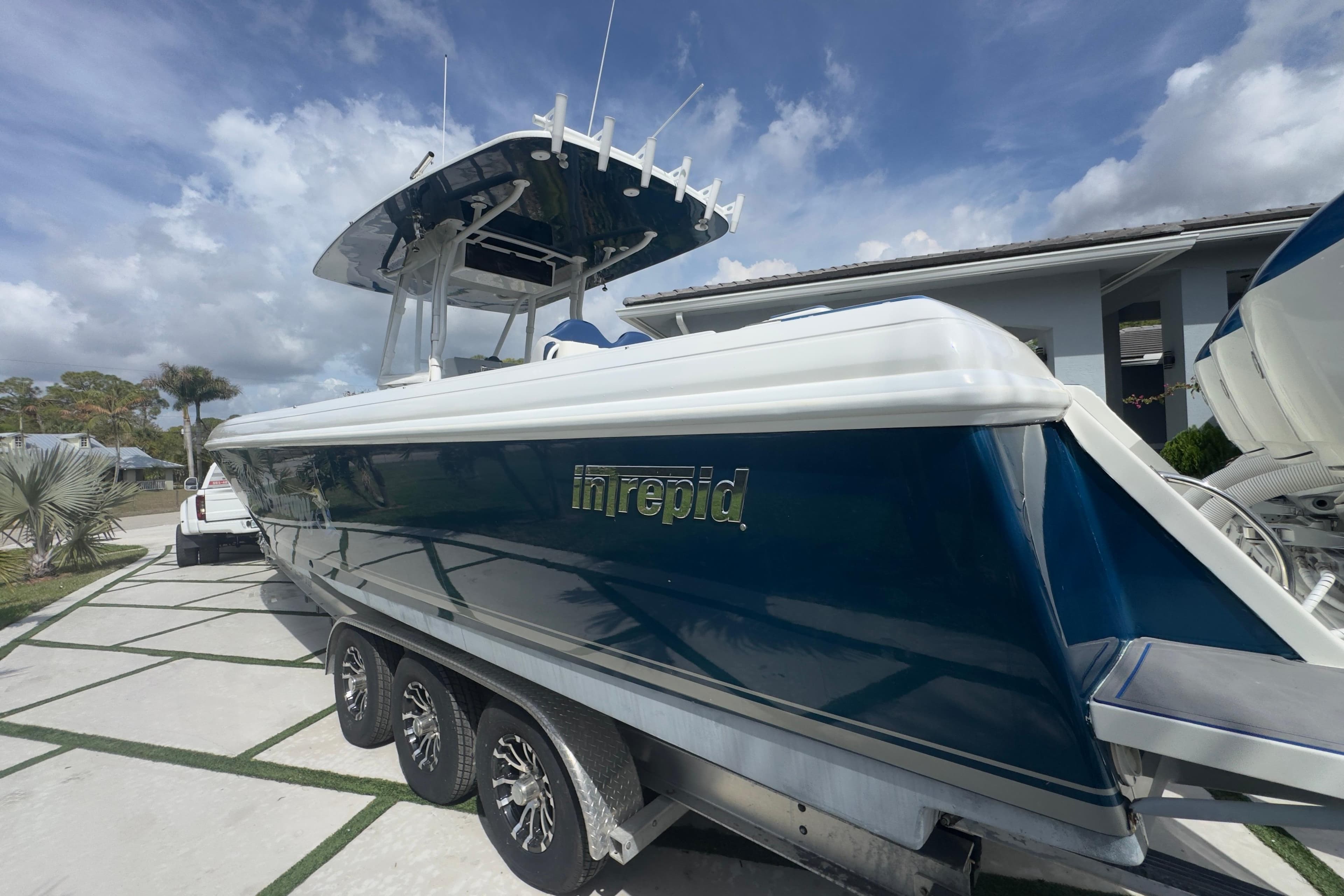 2007 Intrepid 370 Center Console boat on trailer, parked outdoors under a cloudy sky.