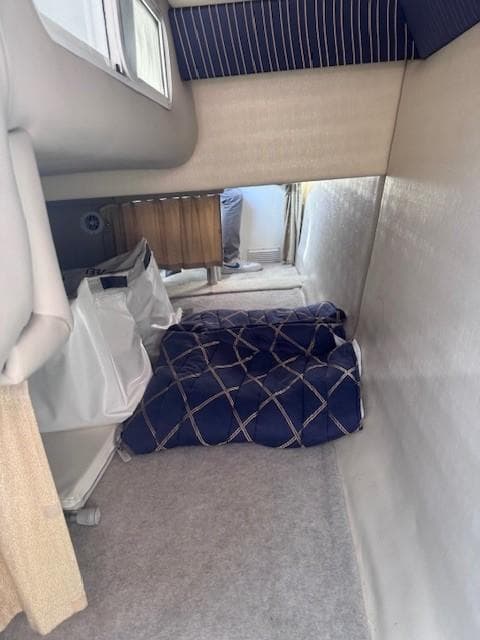 Interior cabin of 2003 Formula 27 PC boat with blue bedding and storage.