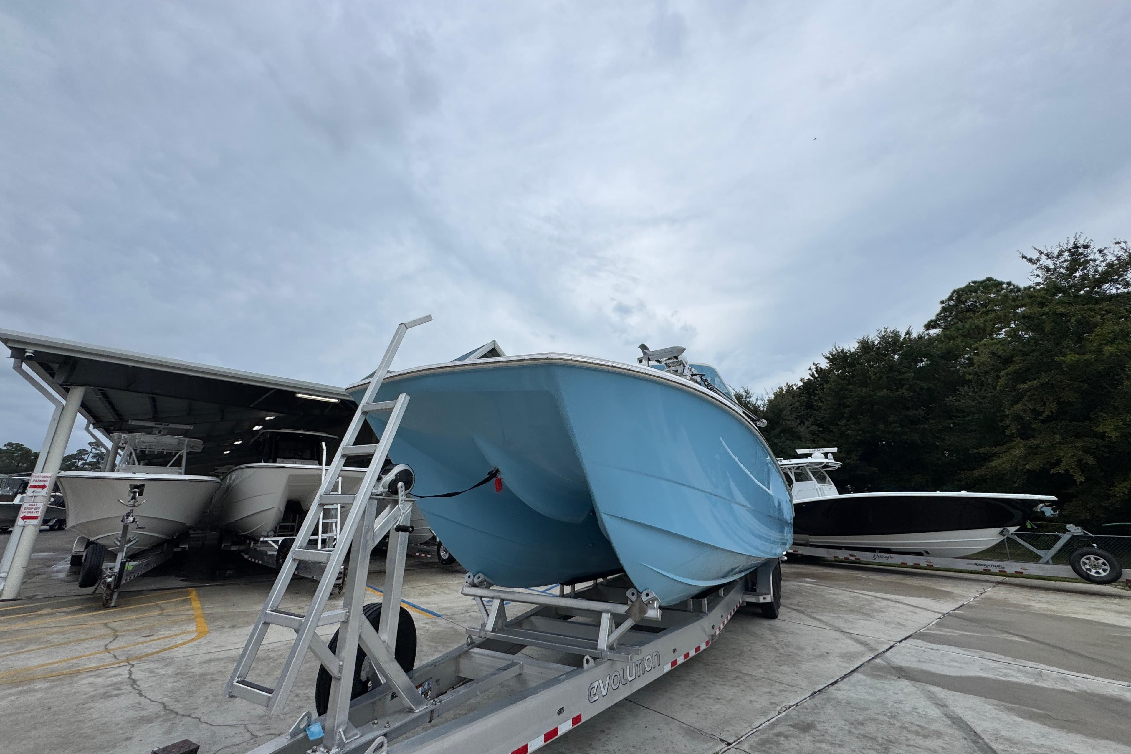 2025 Invincible 40 Catamaran on trailer, parked outdoors under cloudy sky.