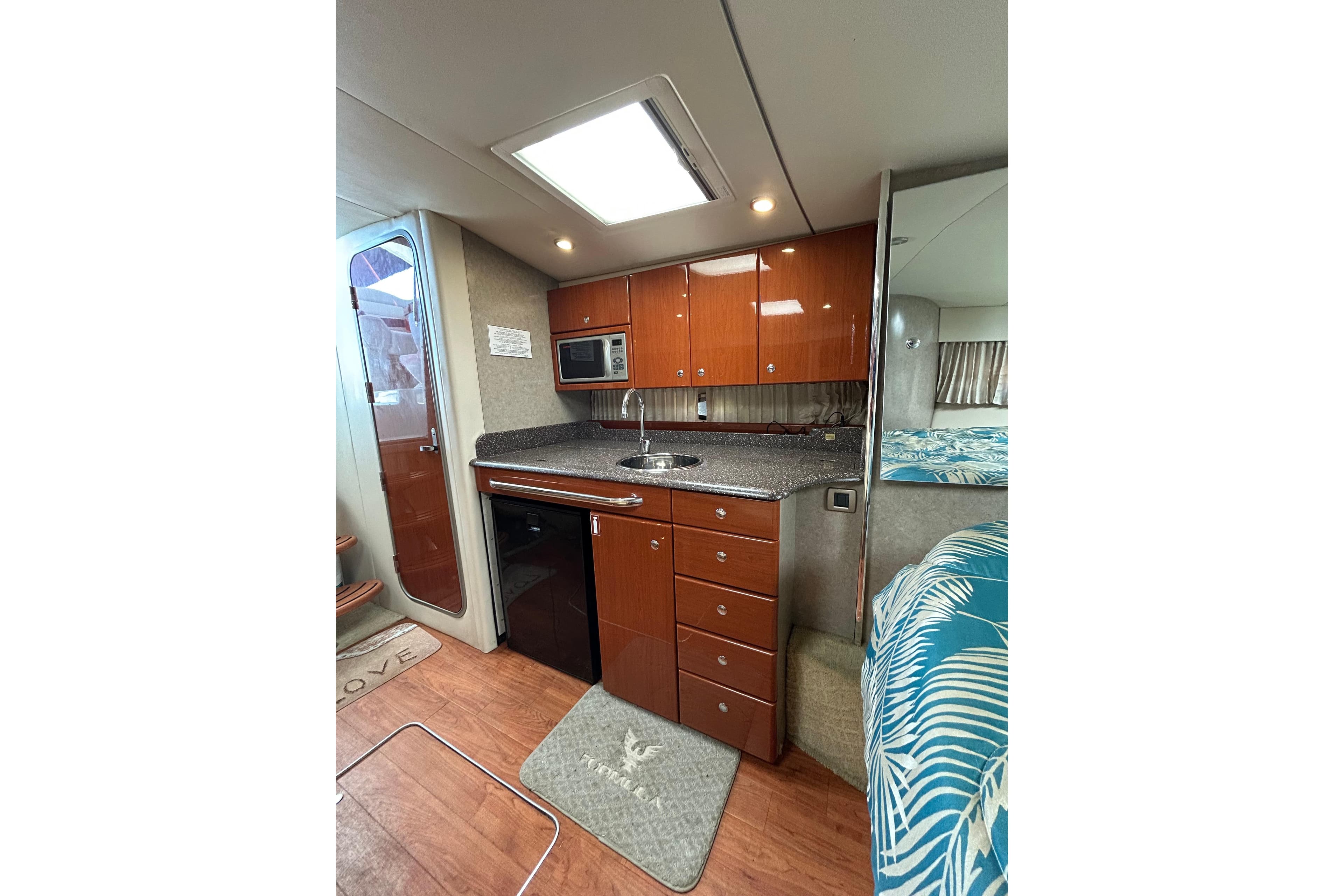 2008 Formula 34 Performance Cruiser interior with kitchenette, wood cabinets, and modern appliances.