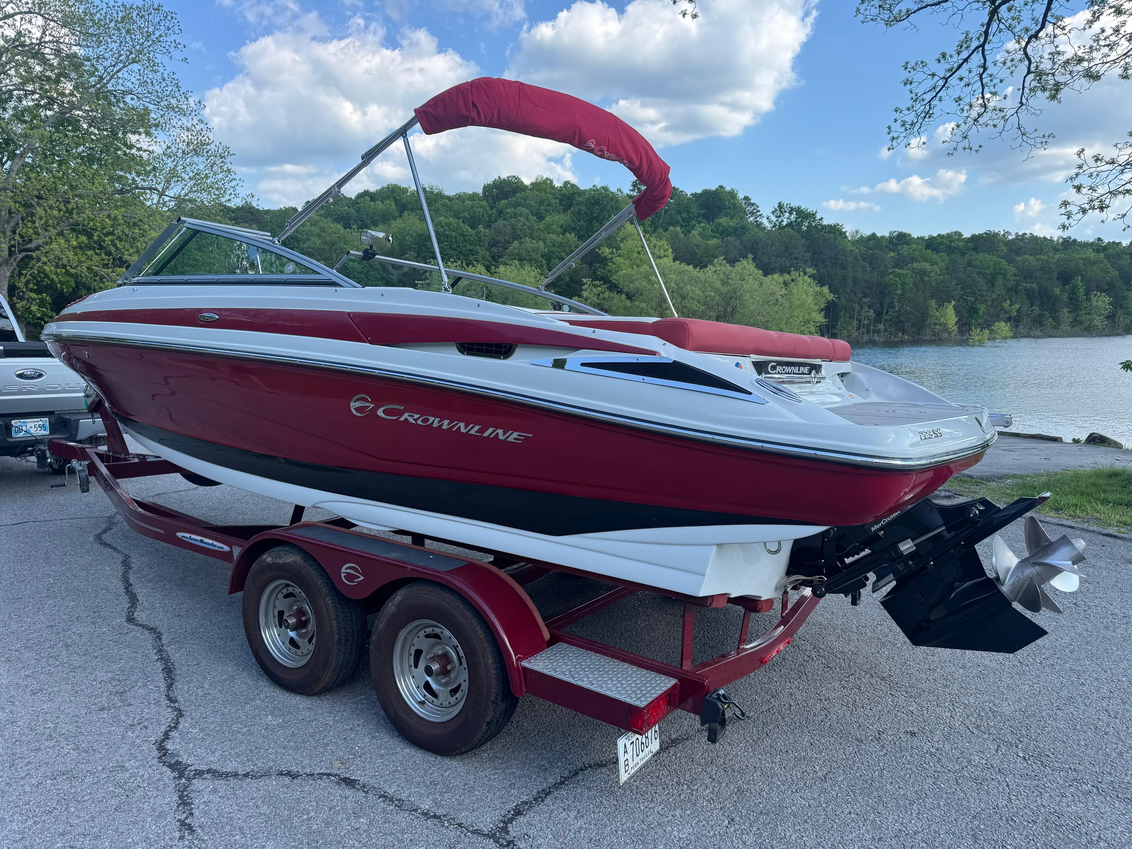 2018 Crownline 225SS boat on trailer by a lake, red and white design.