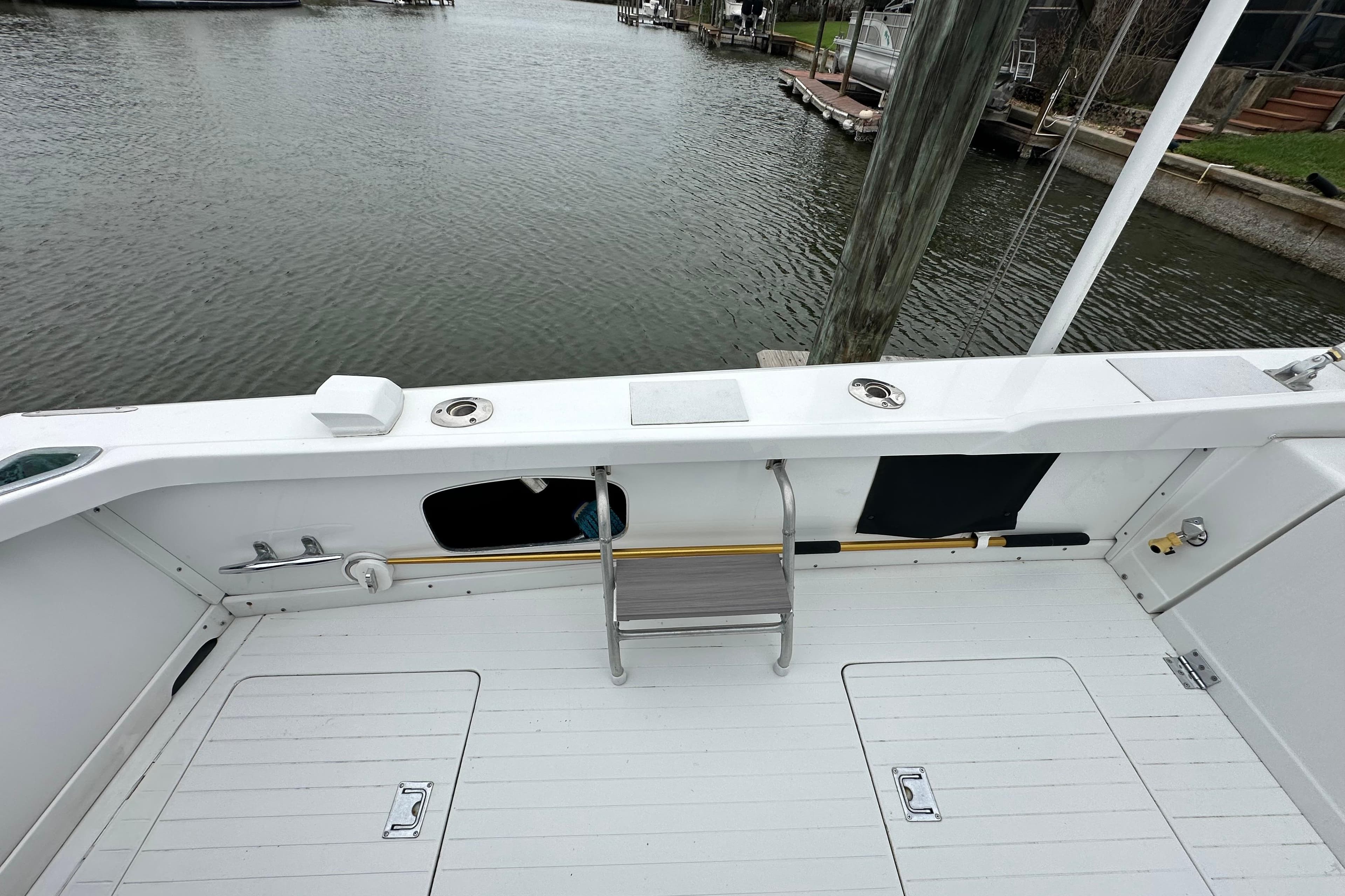 1975 Bertram 31 boat deck with ladder, docked by calm waters.