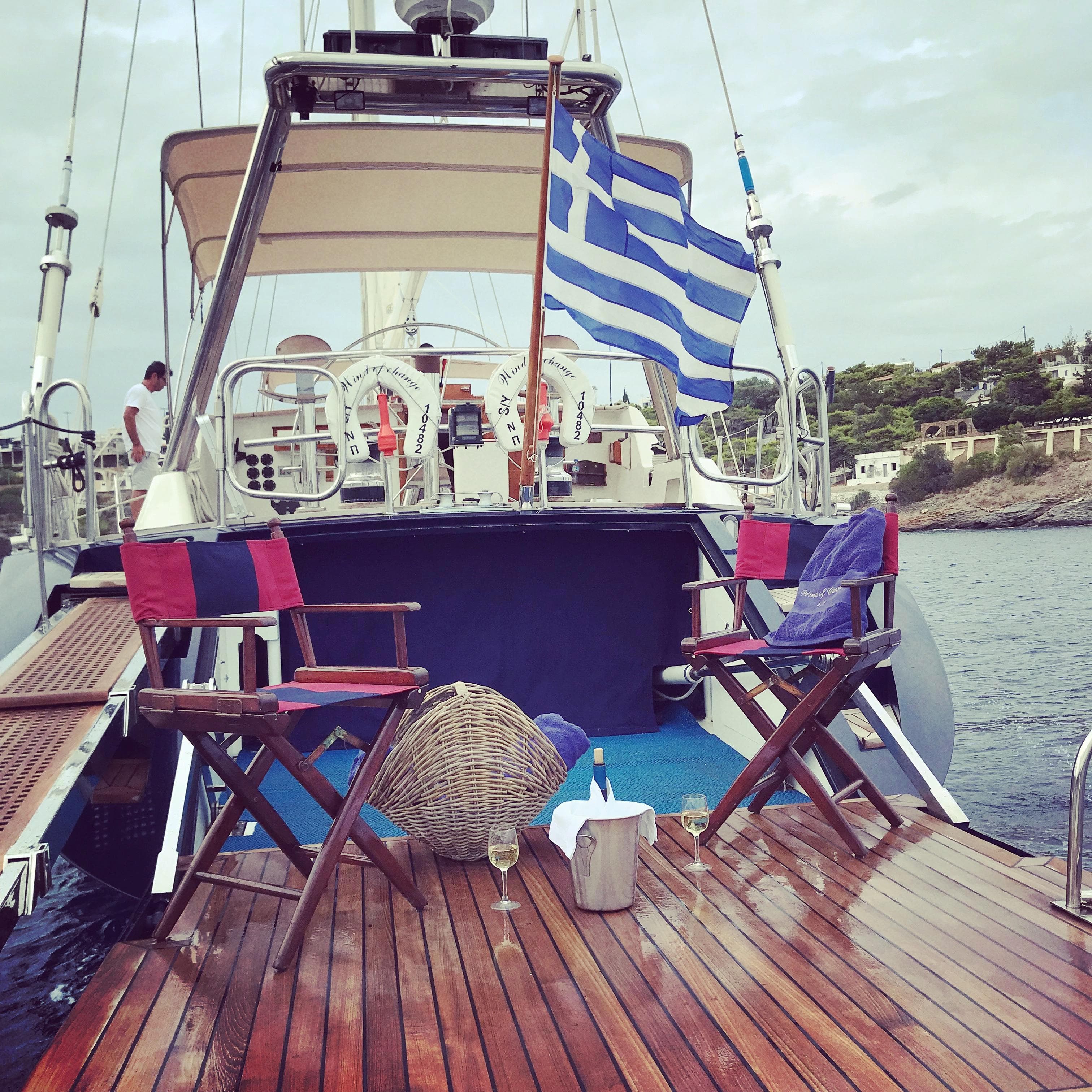 1988 Brooke Marine Motorsailer with Greek flag, deck chairs, and wine setup.