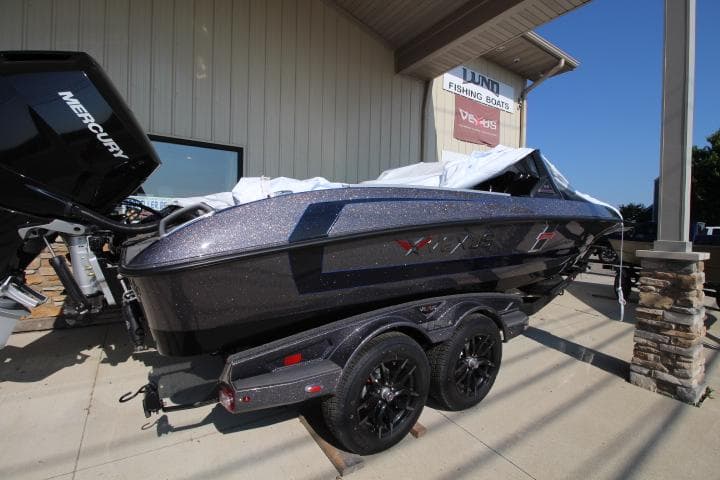 2025 Vexus DVX22S boat on trailer outside dealership, featuring sleek design and Mercury engine.
