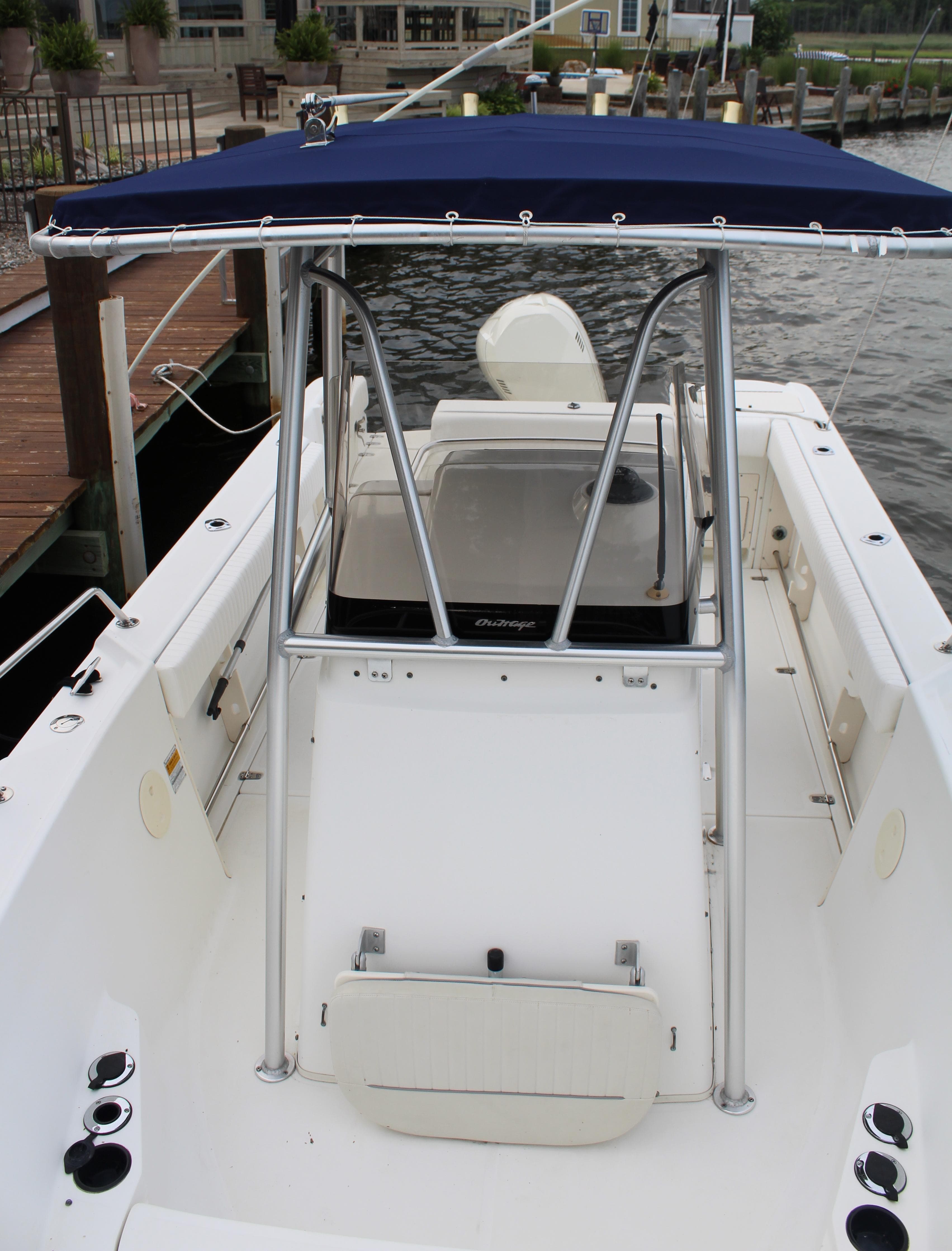 1999 Boston Whaler Outrage 23 boat docked, featuring a blue T-top and center console.
