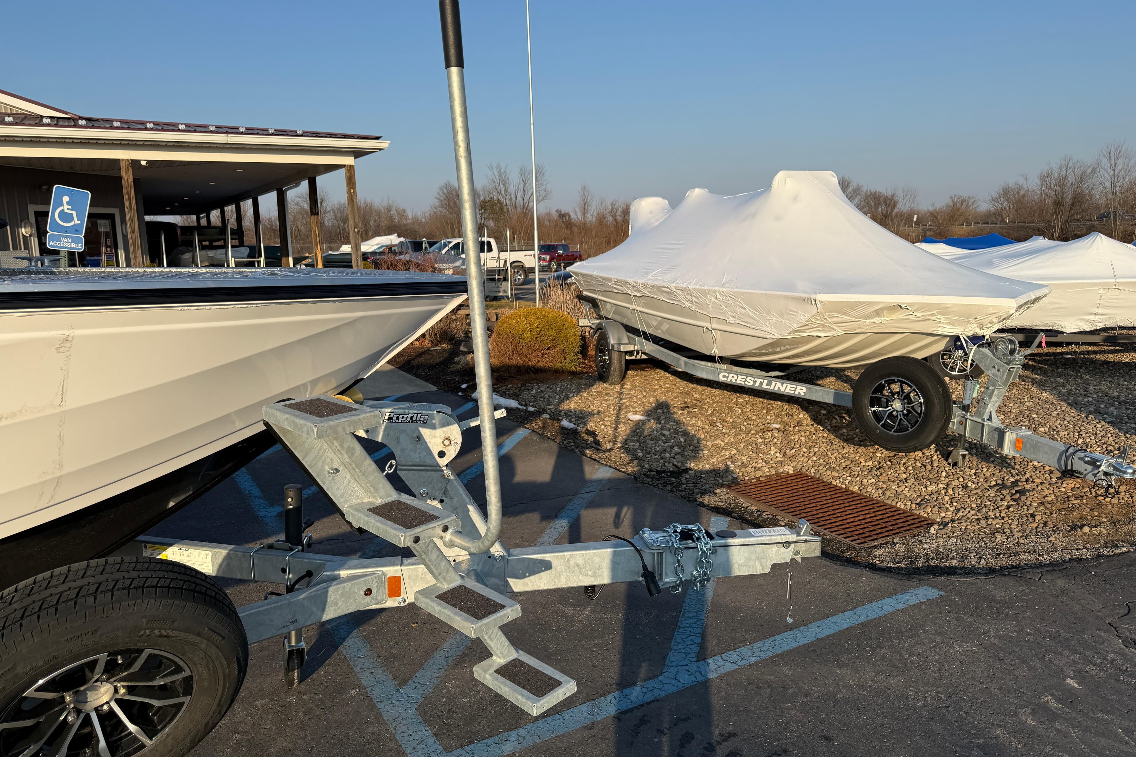2026 Crestliner 1850 Commander Elite boats on trailers, covered and parked outdoors.