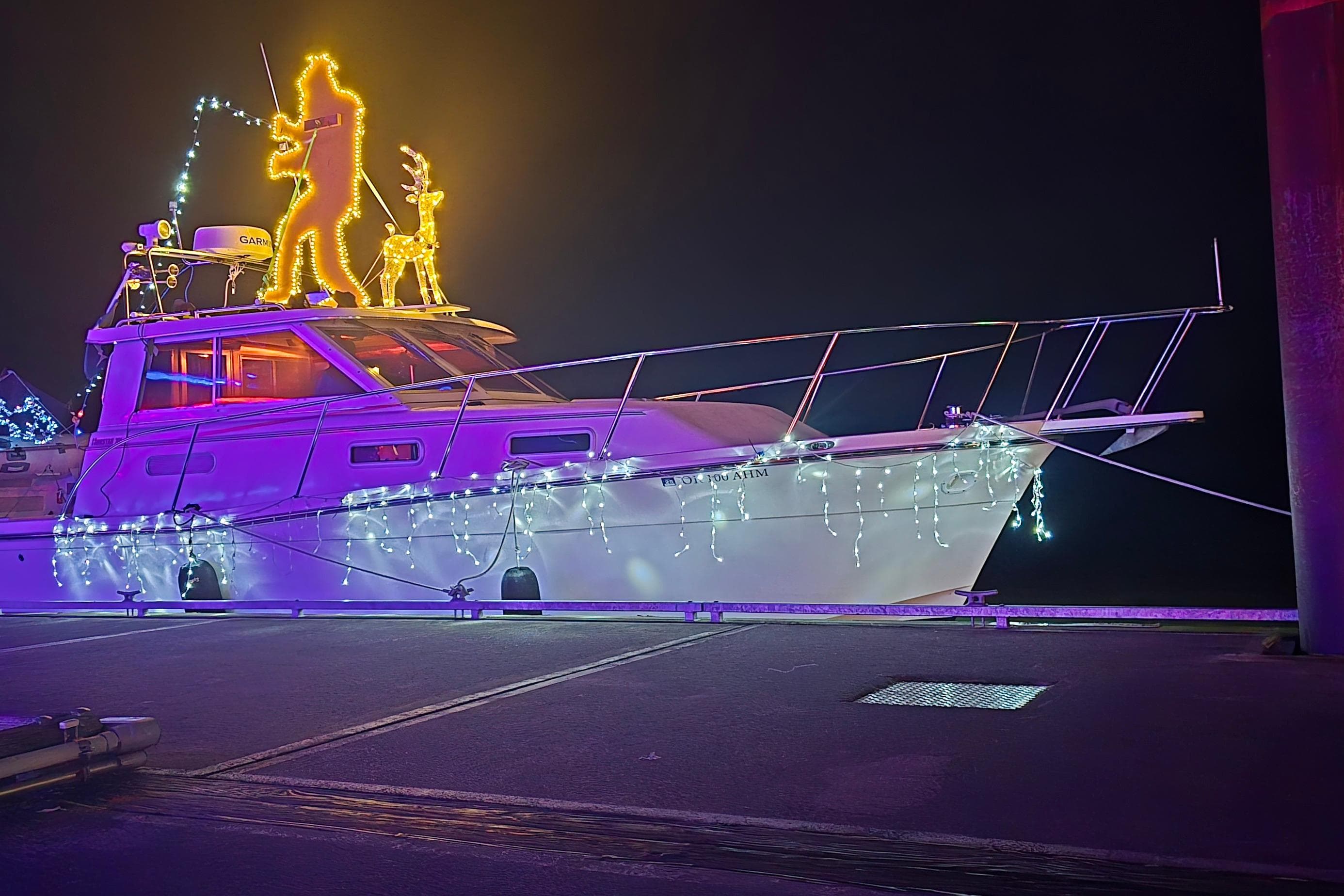 1997 Norstar 301 boat adorned with festive lights and holiday decorations at night.