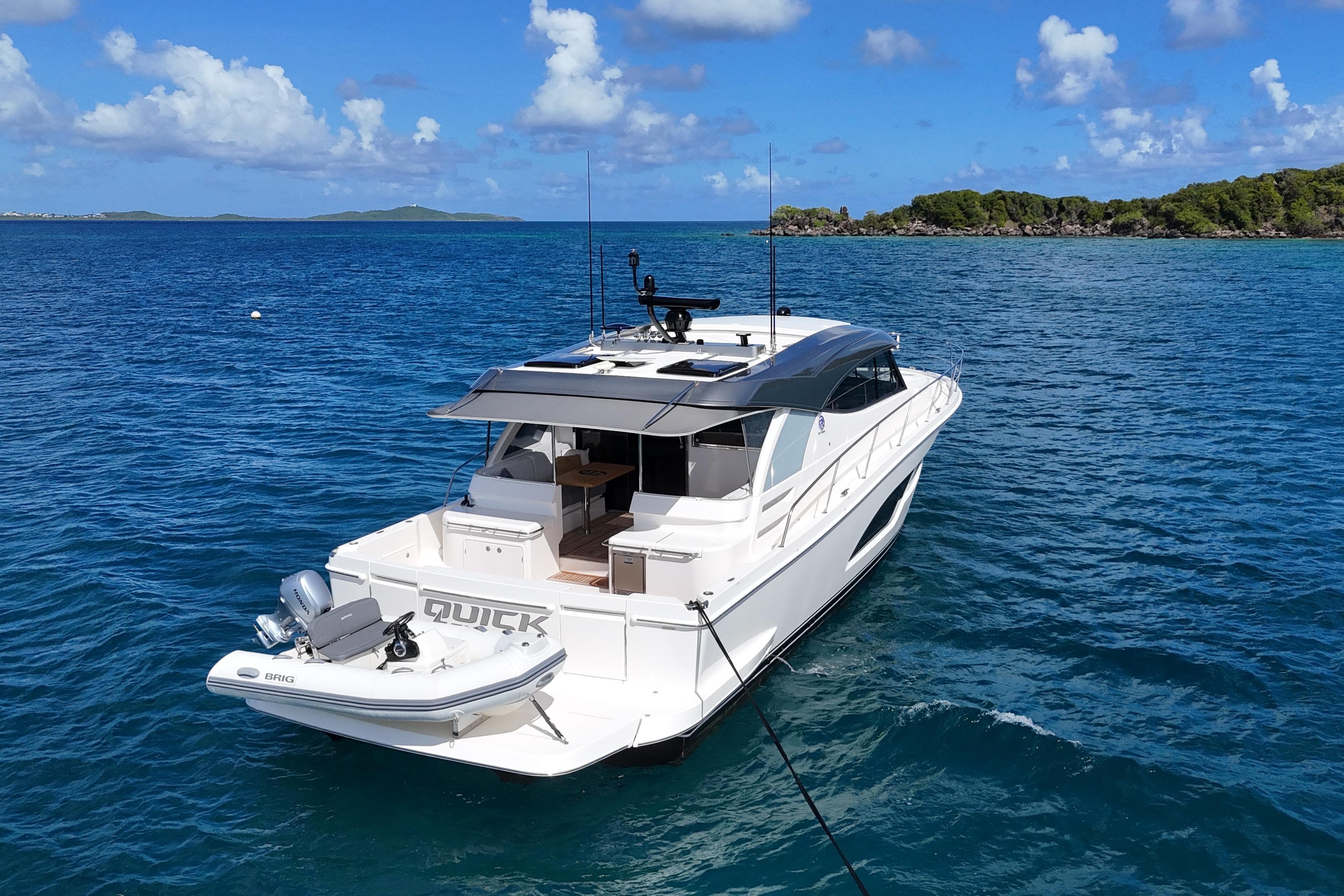 2023 Riviera 465 SUV yacht anchored in clear blue ocean waters.