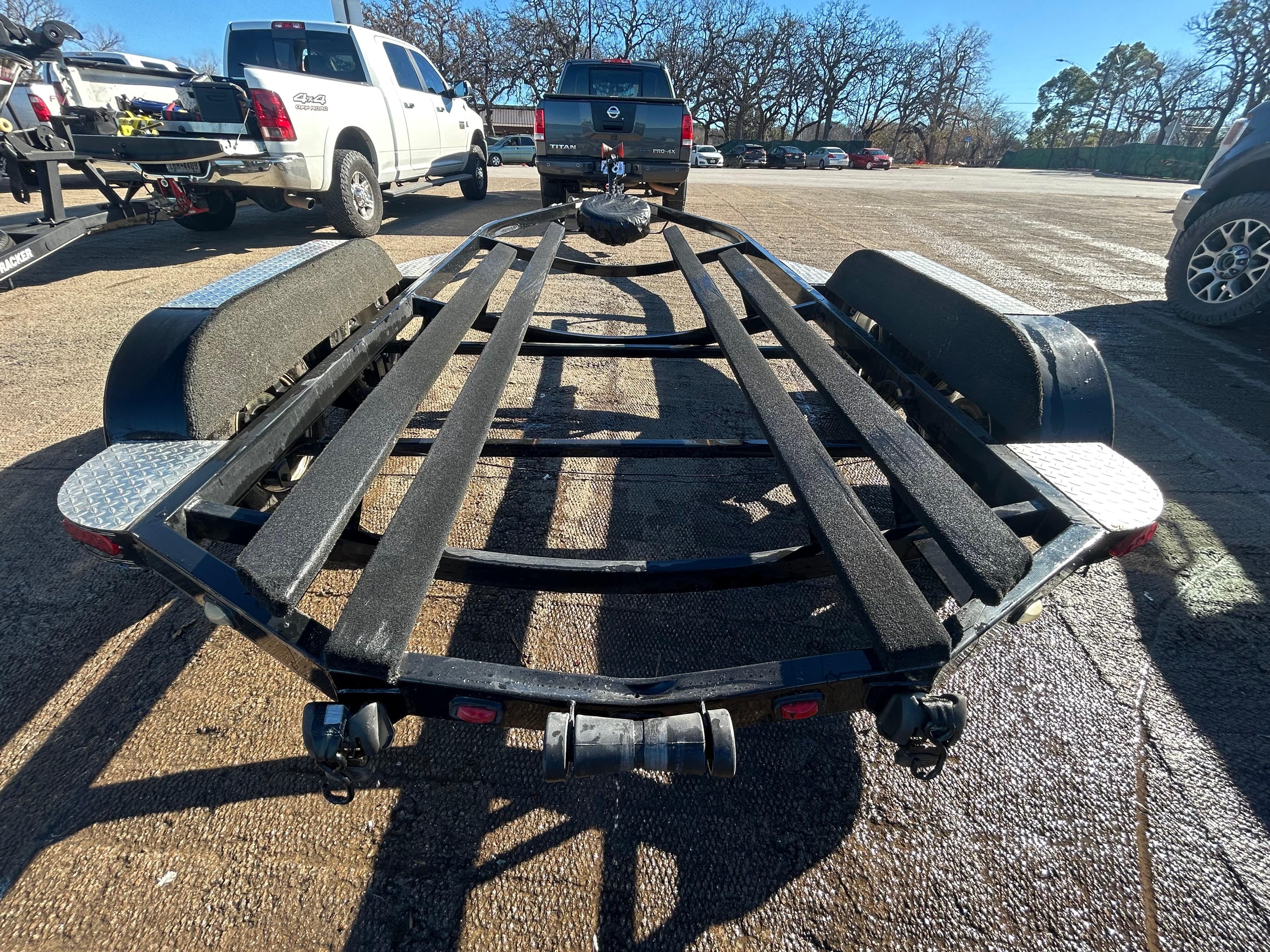 2009 Champion 210 Elite boat trailer in parking lot, surrounded by trucks.