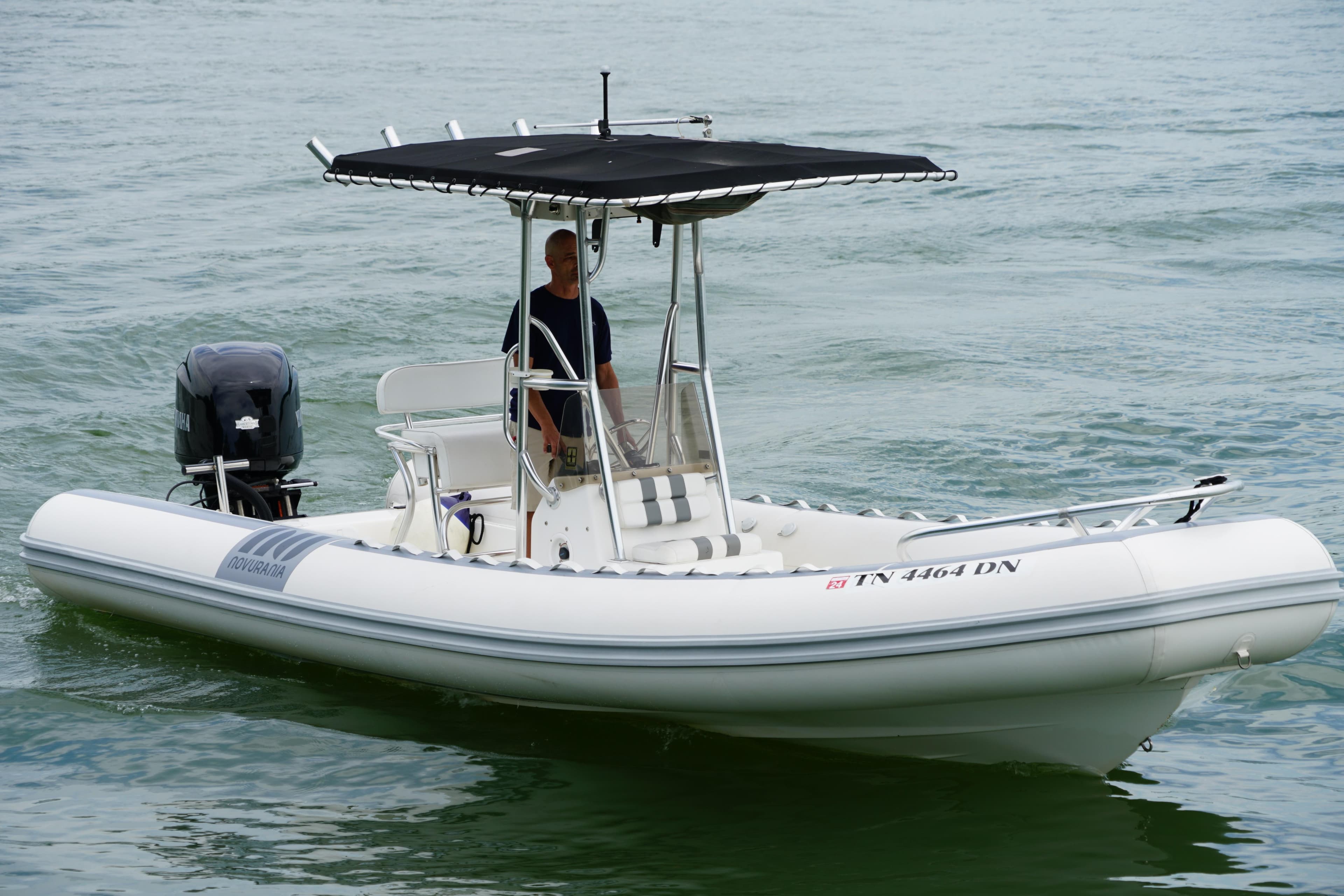 2003 Novurania 24 boat with canopy cruising on water.