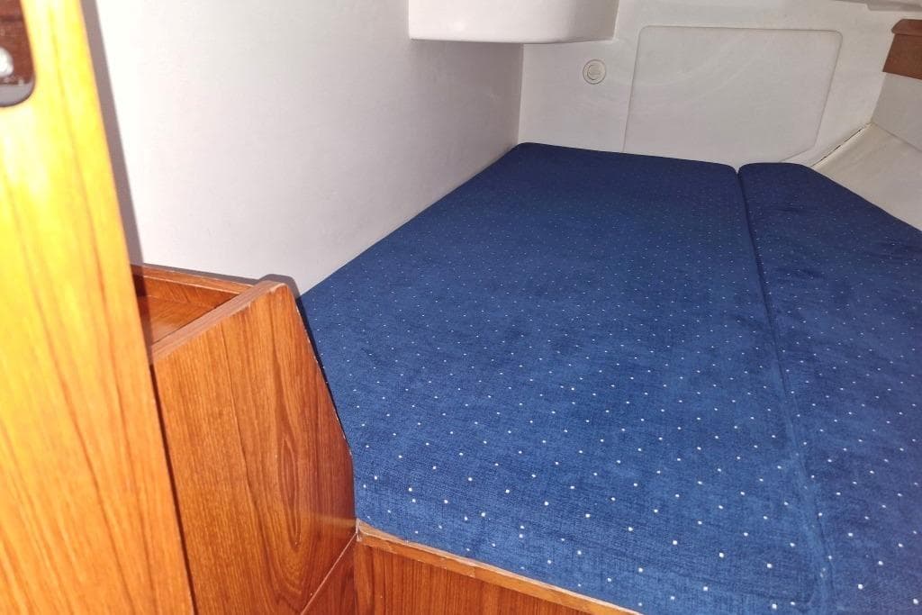 Interior cabin of 2001 Jeanneau Sun Odyssey 34.2 with blue bedding.
