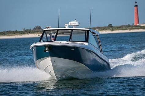Manufacturer Provided Image: 2019 Everglades 340 Dual Console boat cruising on water near a lighthouse.