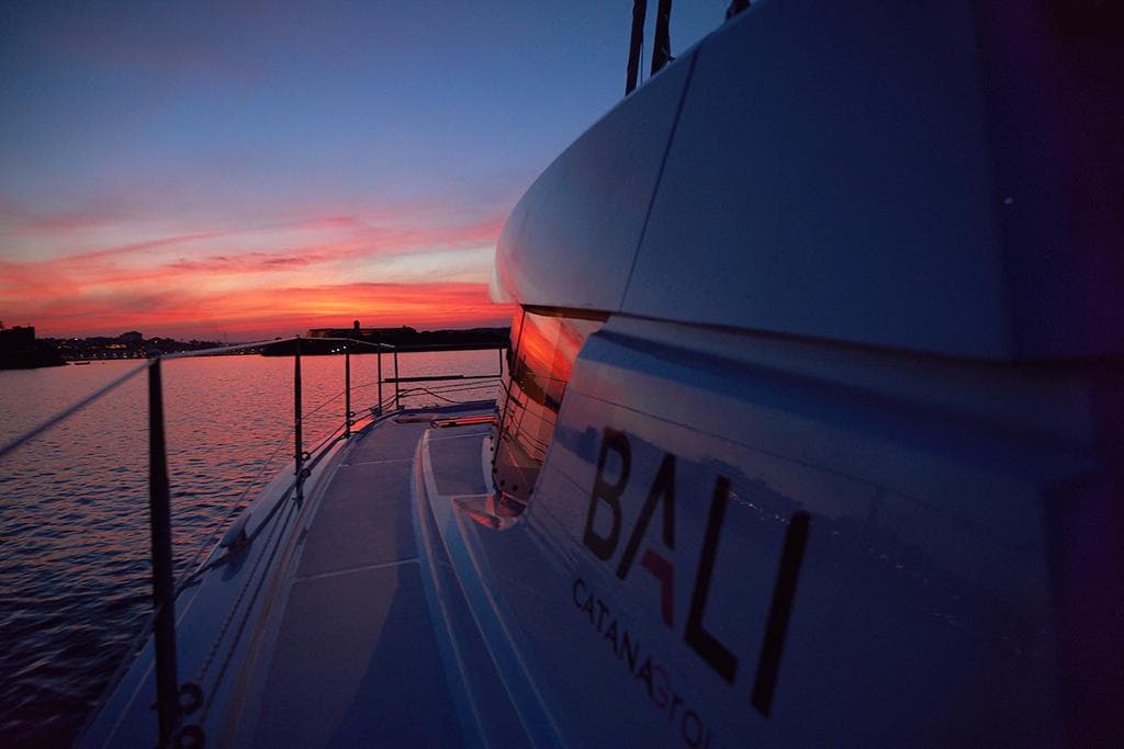 Bali 4.4 catamaran at sunset, 2026 model, sailing on calm waters.