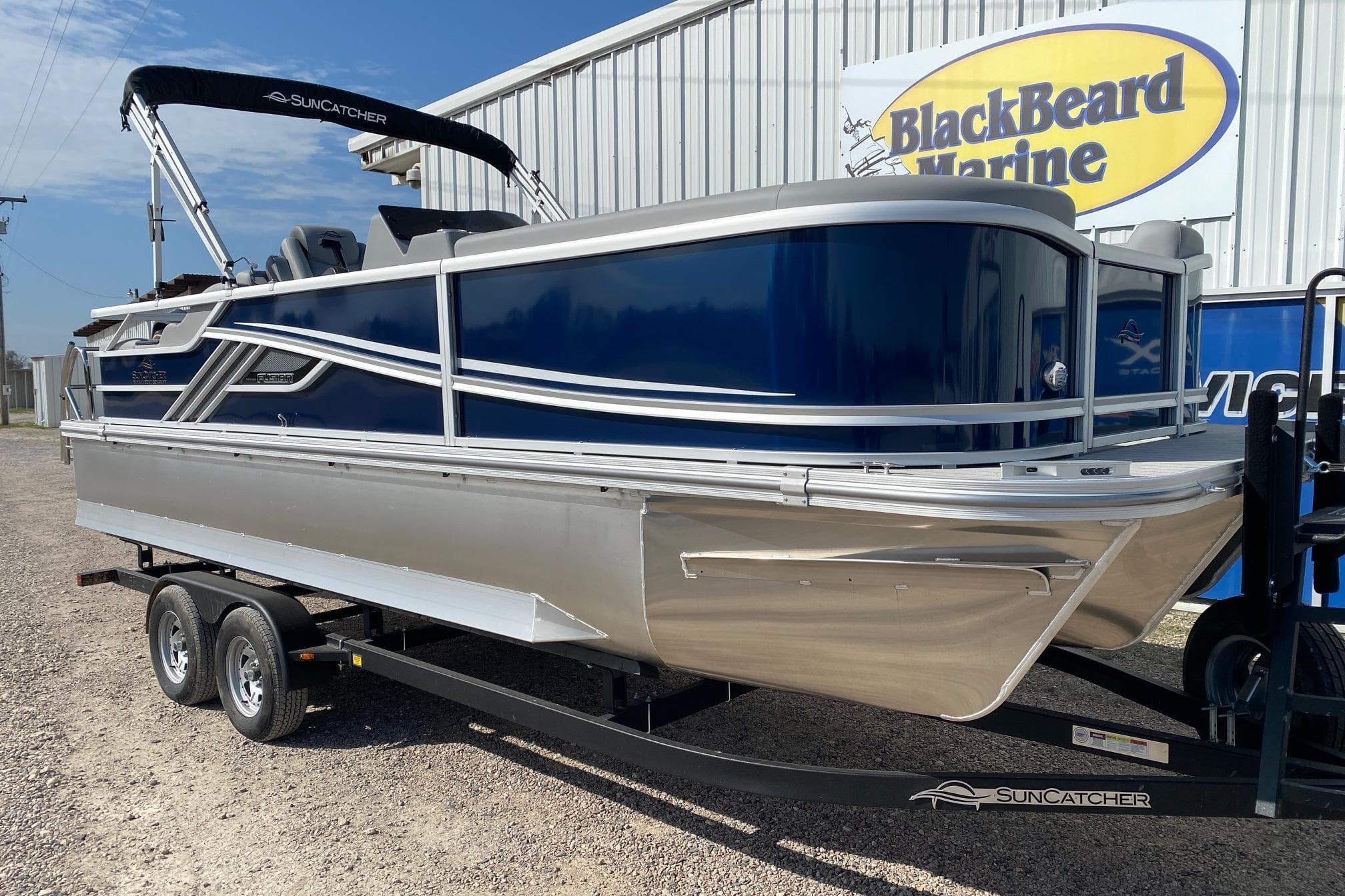 2026 SunCatcher Fusion 322SS pontoon boat on trailer at BlackBeard Marine dealership.