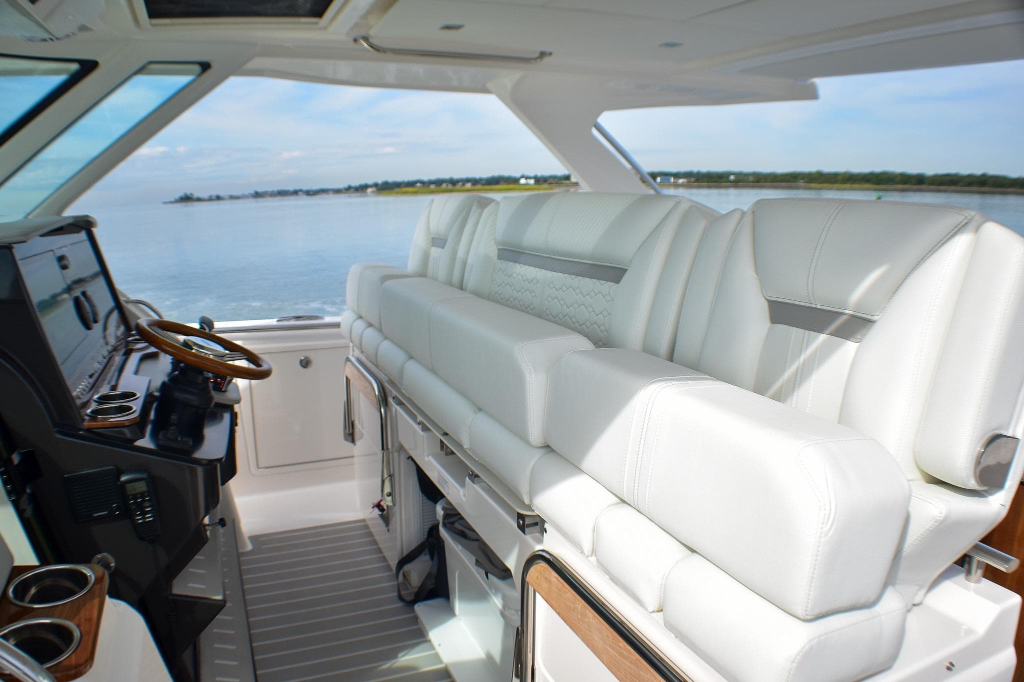 2025 Tiara Yachts 43 LS interior with luxurious white seating and modern helm.