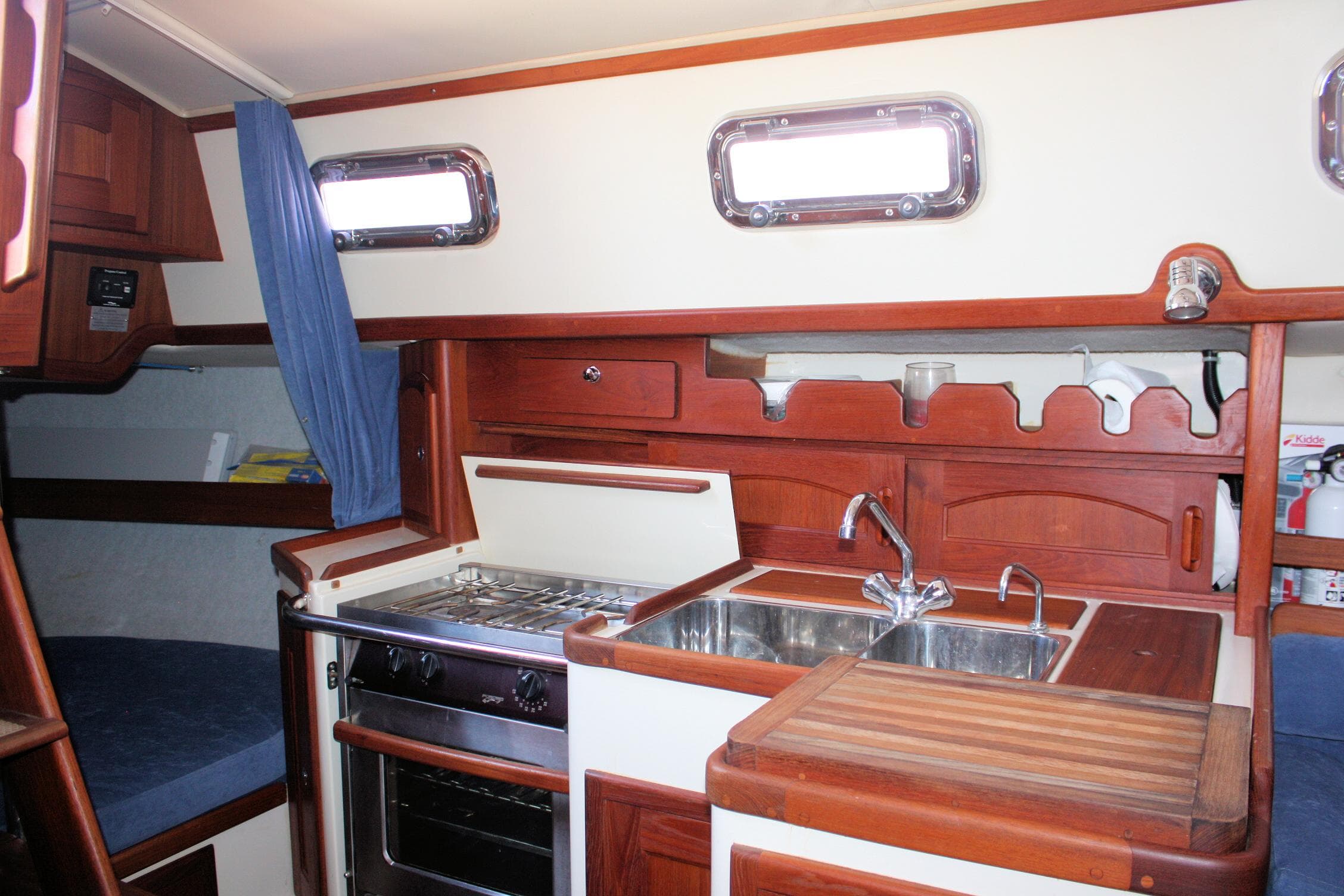Interior of 2004 Pacific Seacraft 31 sailboat, featuring a compact kitchen with stove and sink.