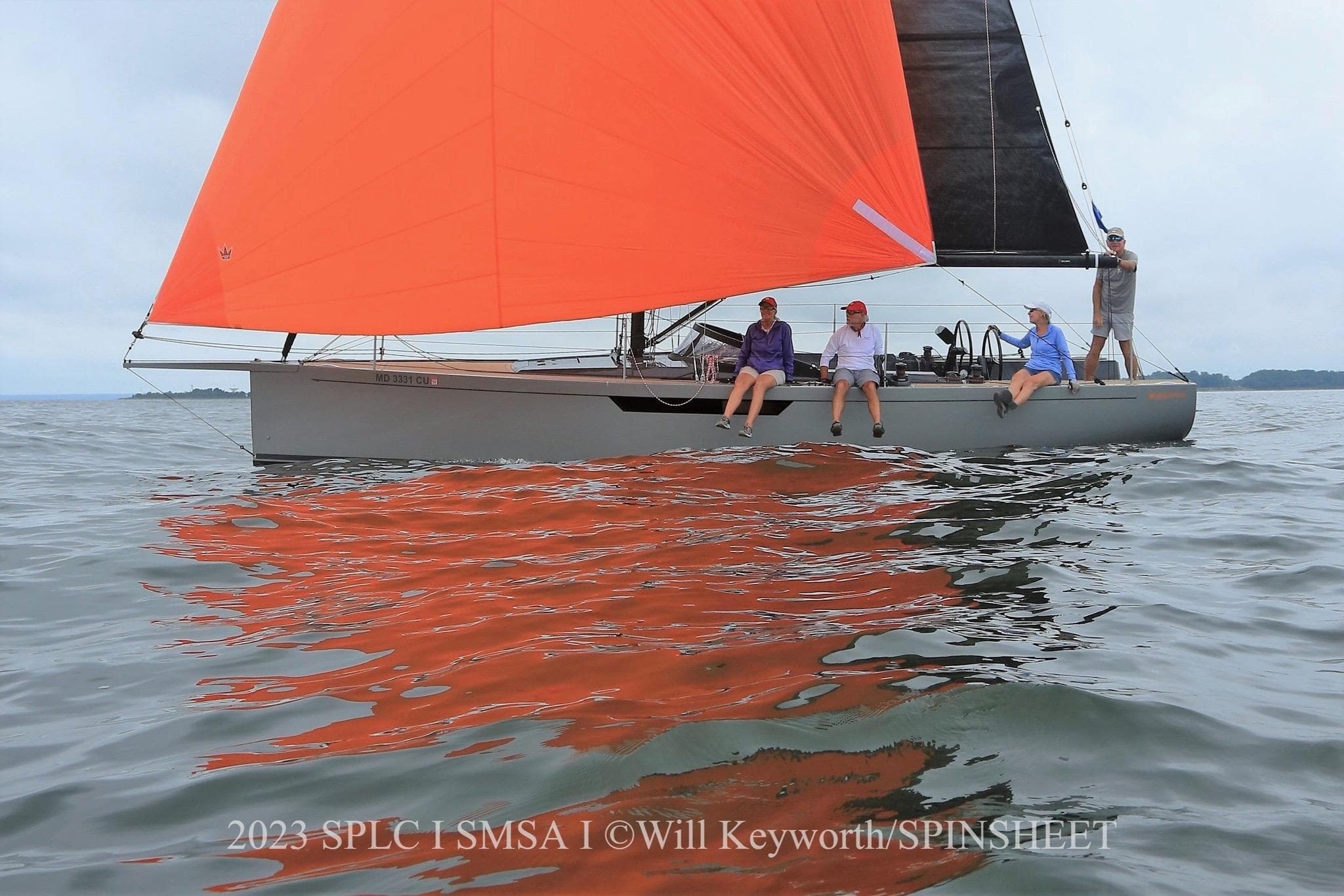 Saffier 33 Life 2022 sailboat with vibrant orange sail on calm waters.