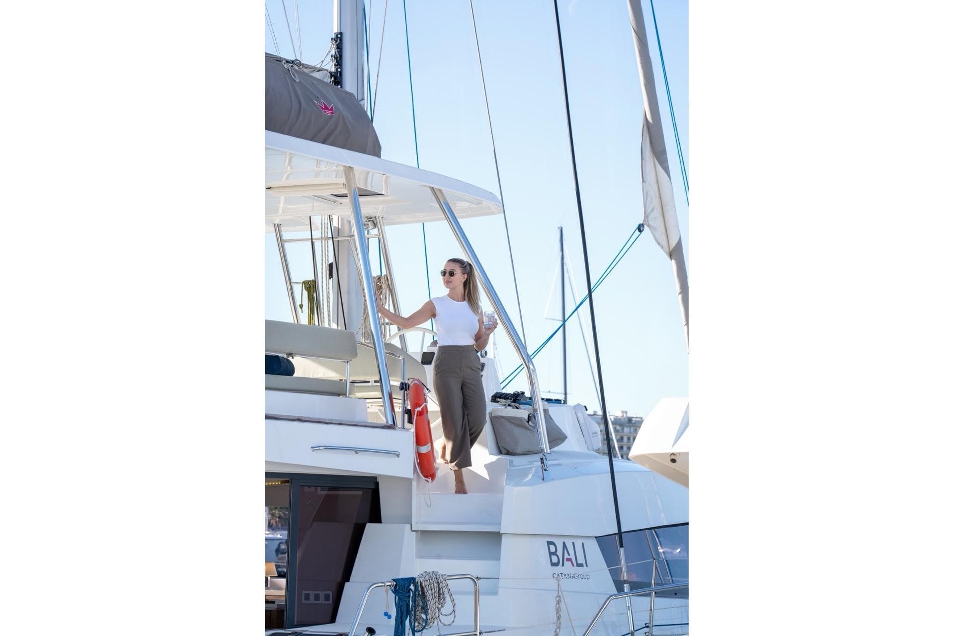 Woman enjoying a drink on a 2023 Bali 5.4 catamaran yacht.