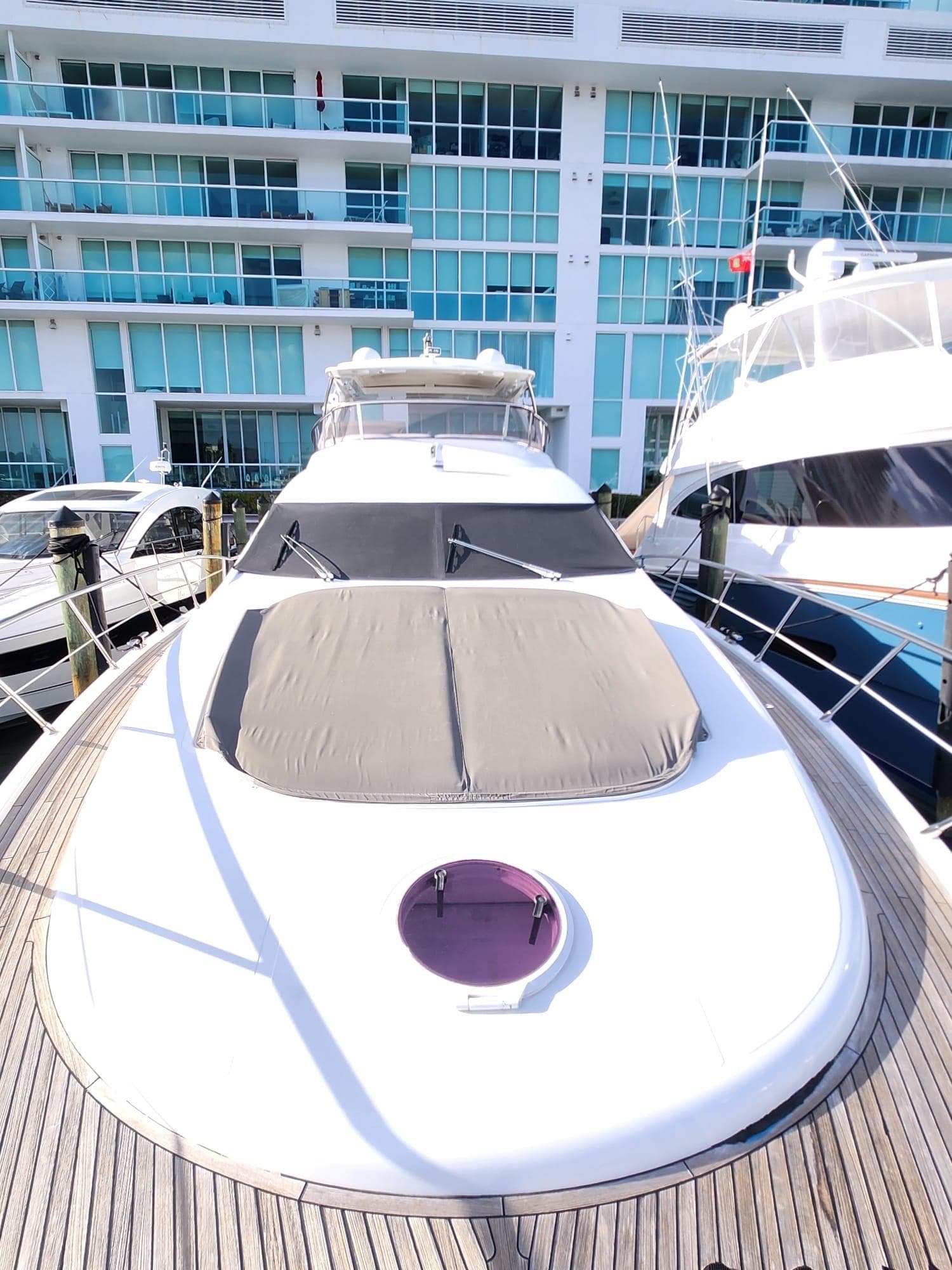2014 Azimut Flybridge yacht docked near modern waterfront building.