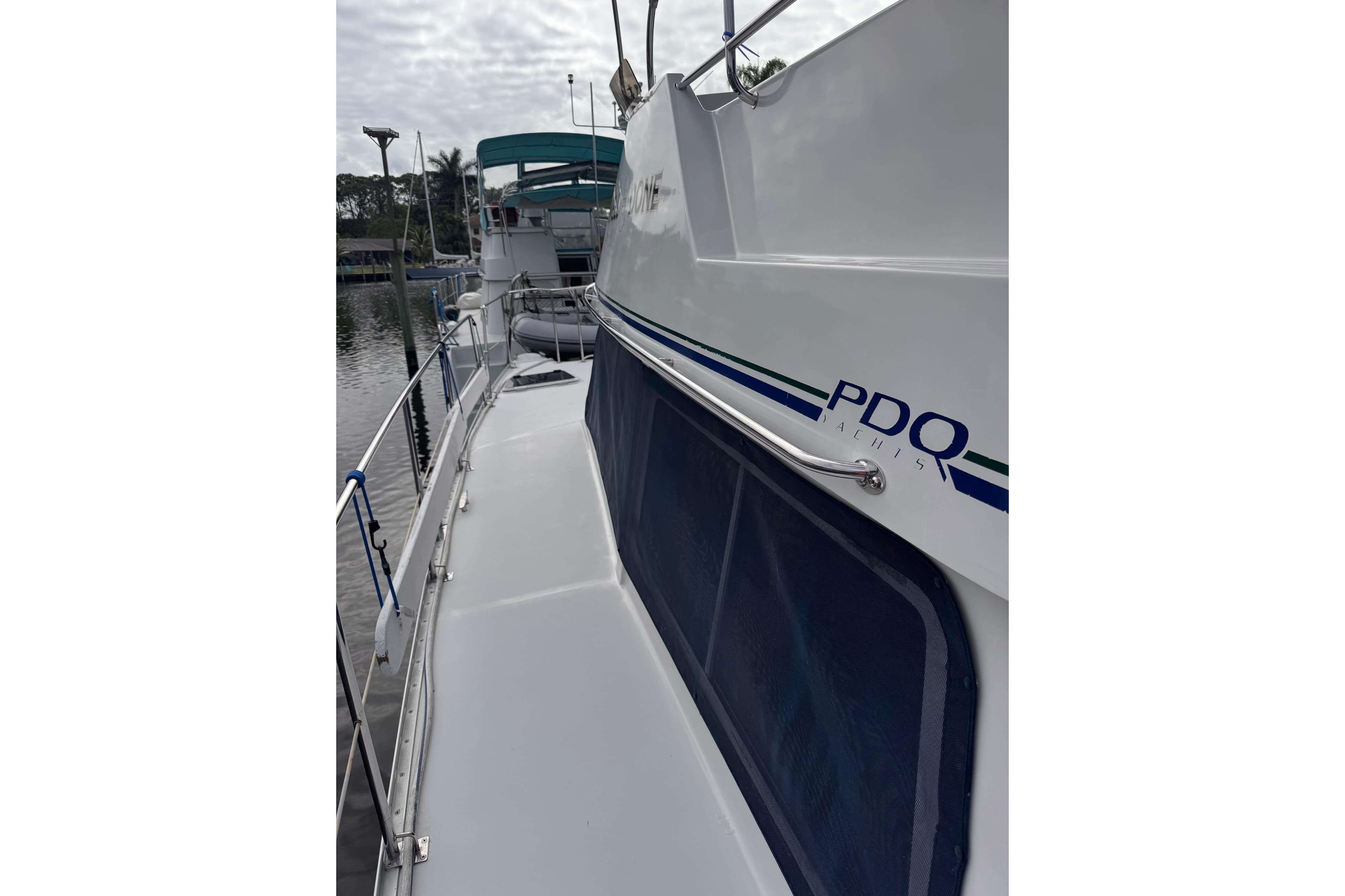 2006 PDQ PowerCat yacht docked, featuring sleek design and railing details.