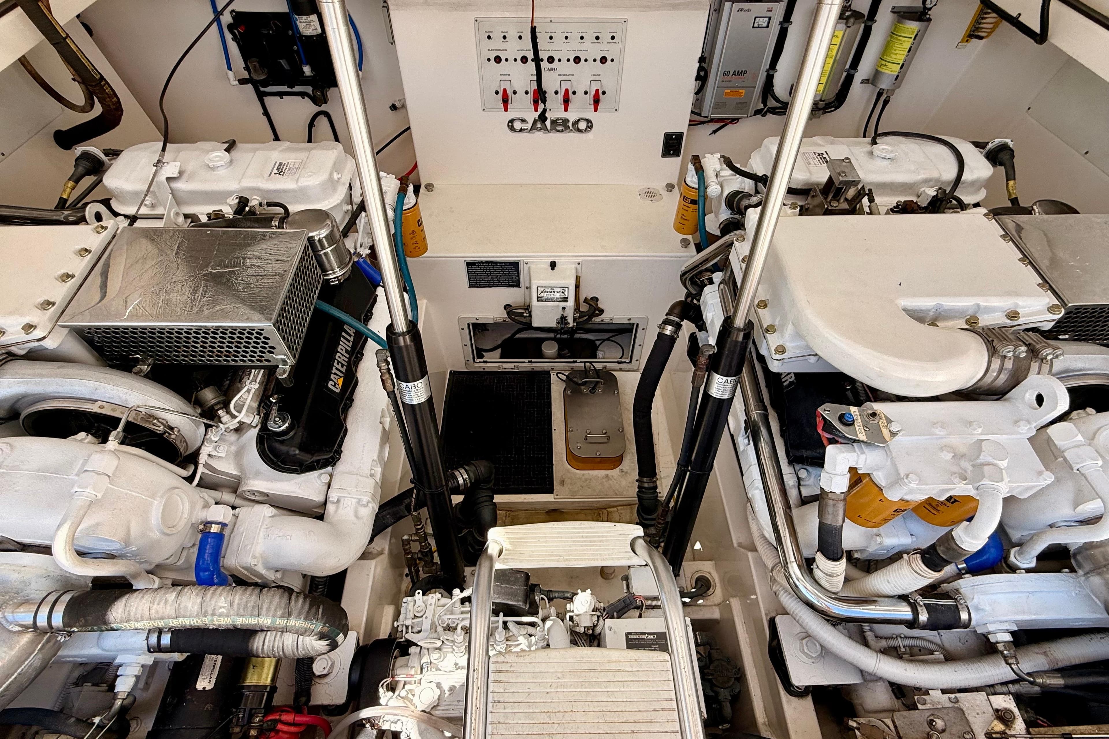 Engine room of a 2001 Cabo 35 Express boat, showcasing dual engines and mechanical components.
