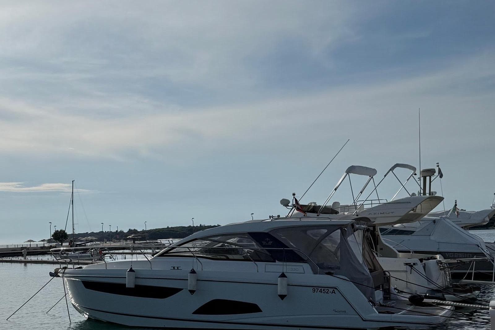 2018 Sealine S330 yacht docked in a serene marina under a clear sky.