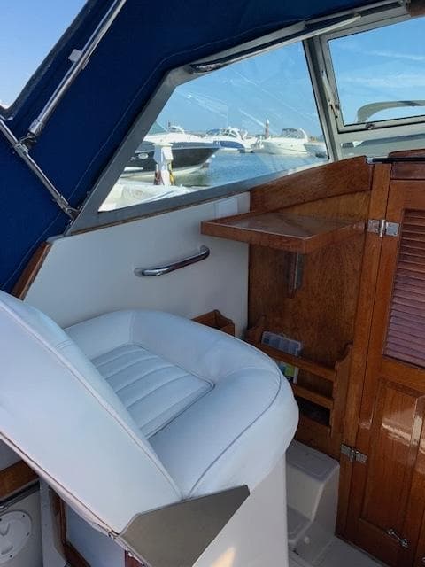 1989 Limestone 24 Express Cruiser interior with white seating and wooden accents.