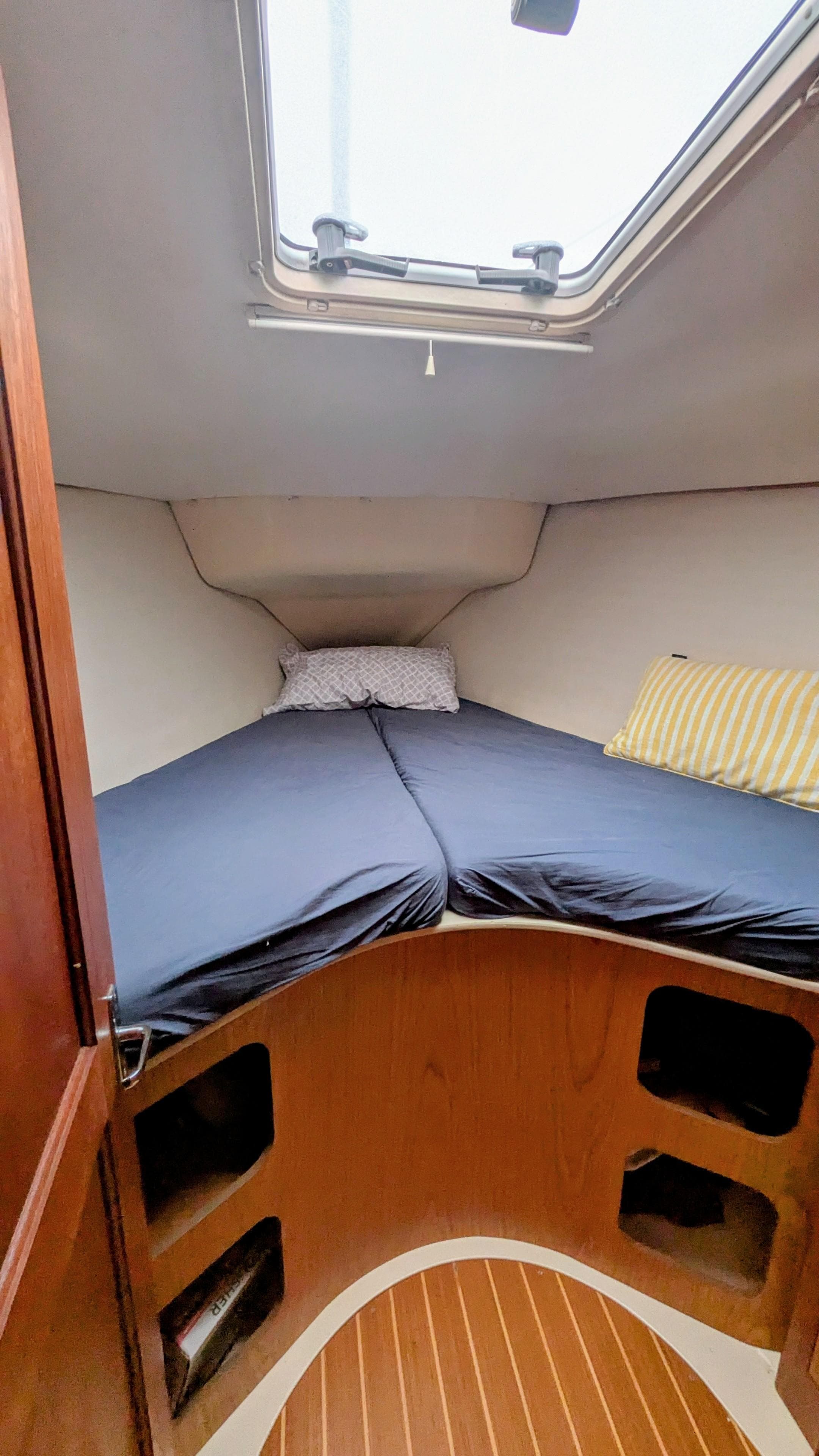 Cozy cabin interior of 2001 Hunter 380 sailboat with skylight and bedding.