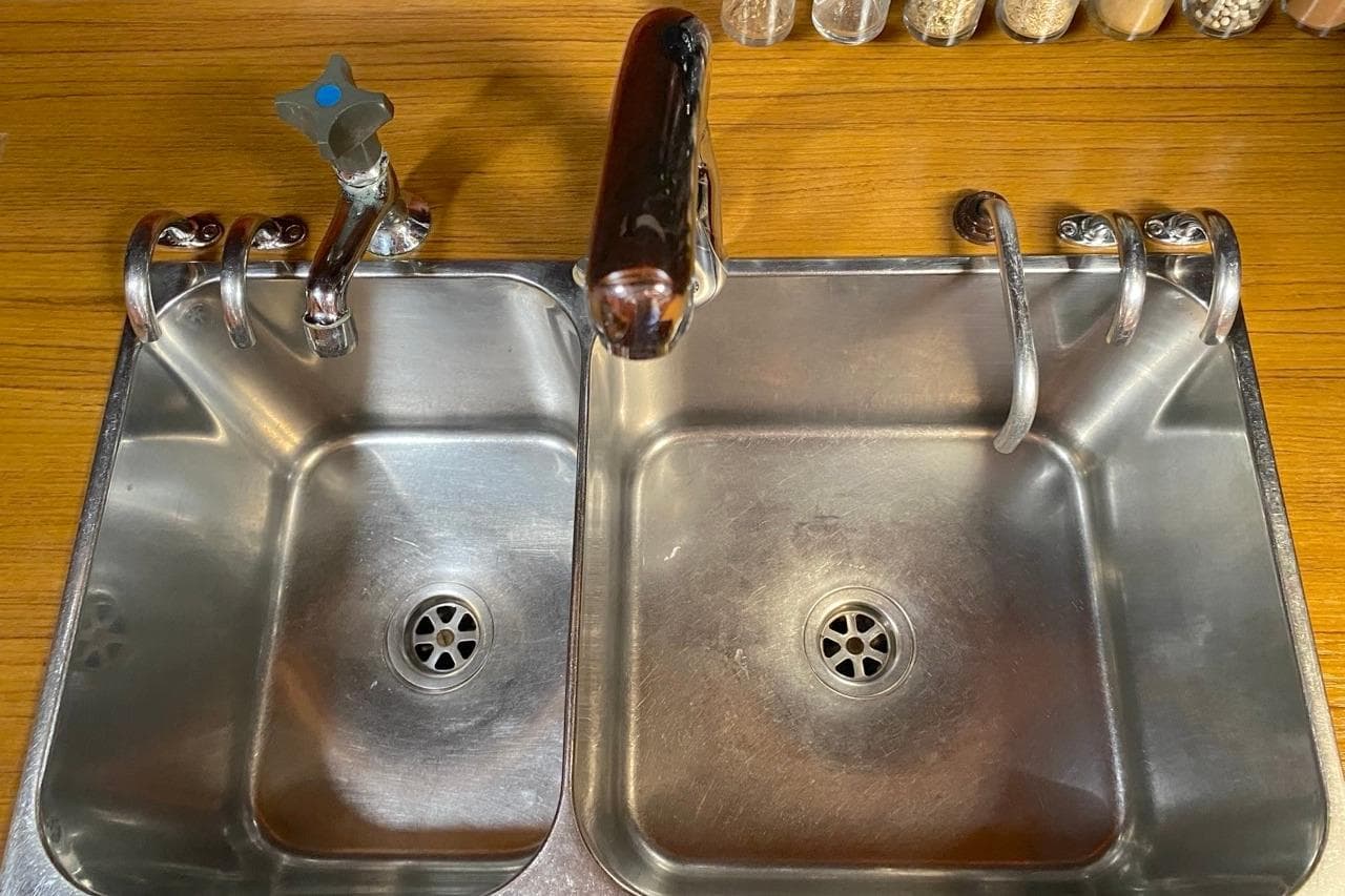 Stainless steel double sink on a 1992 Hallberg-Rassy 45 yacht kitchen counter.