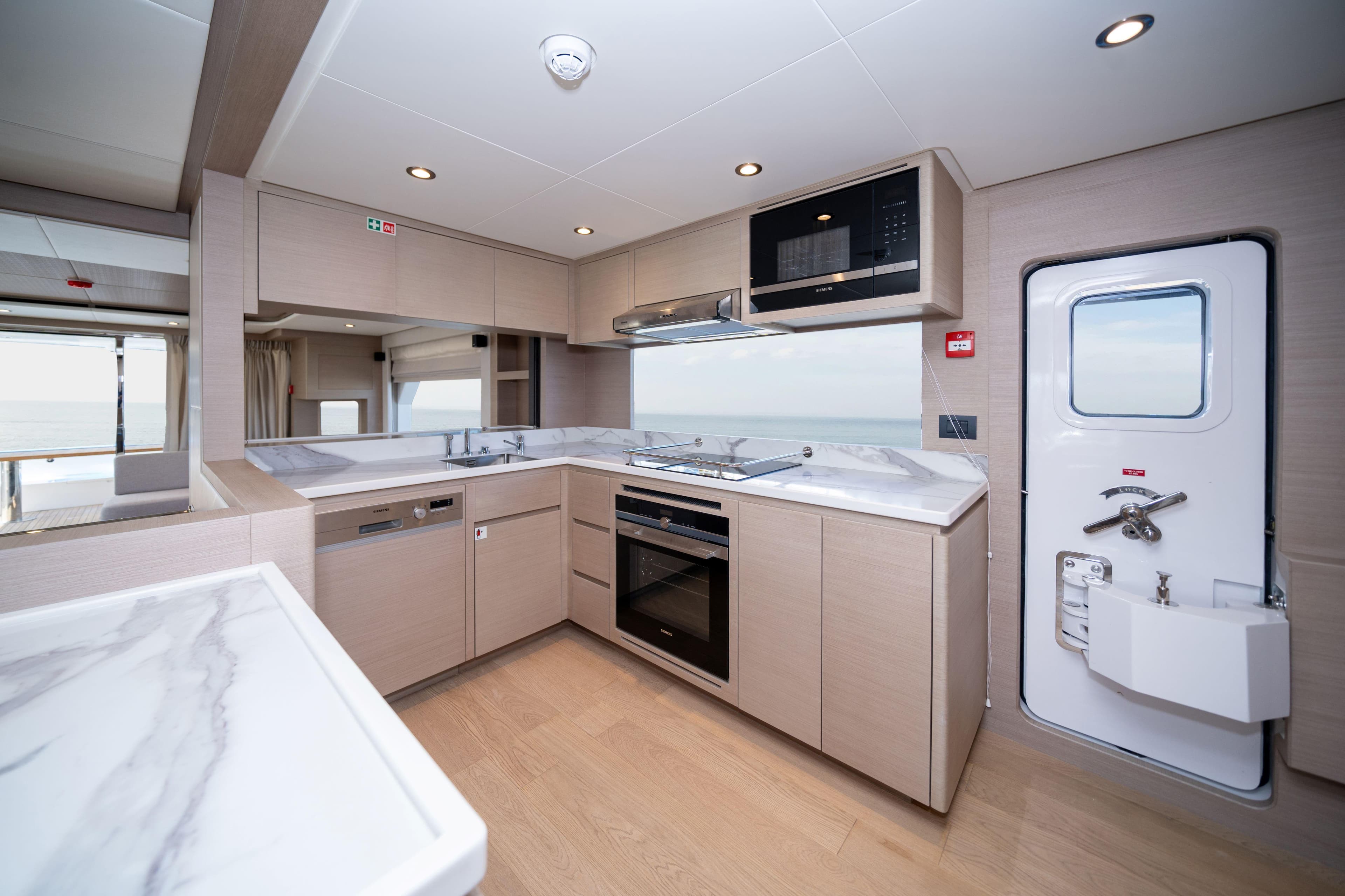 Modern kitchen interior in 2025 Nomad 75 SUV yacht, featuring sleek appliances and ocean view.