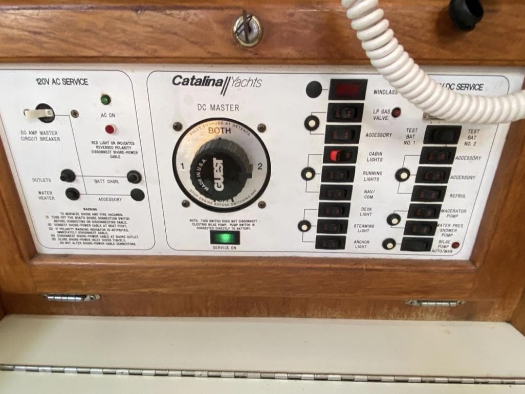 Control panel of a 1995 Catalina 36 MkII yacht, featuring AC and DC service switches.