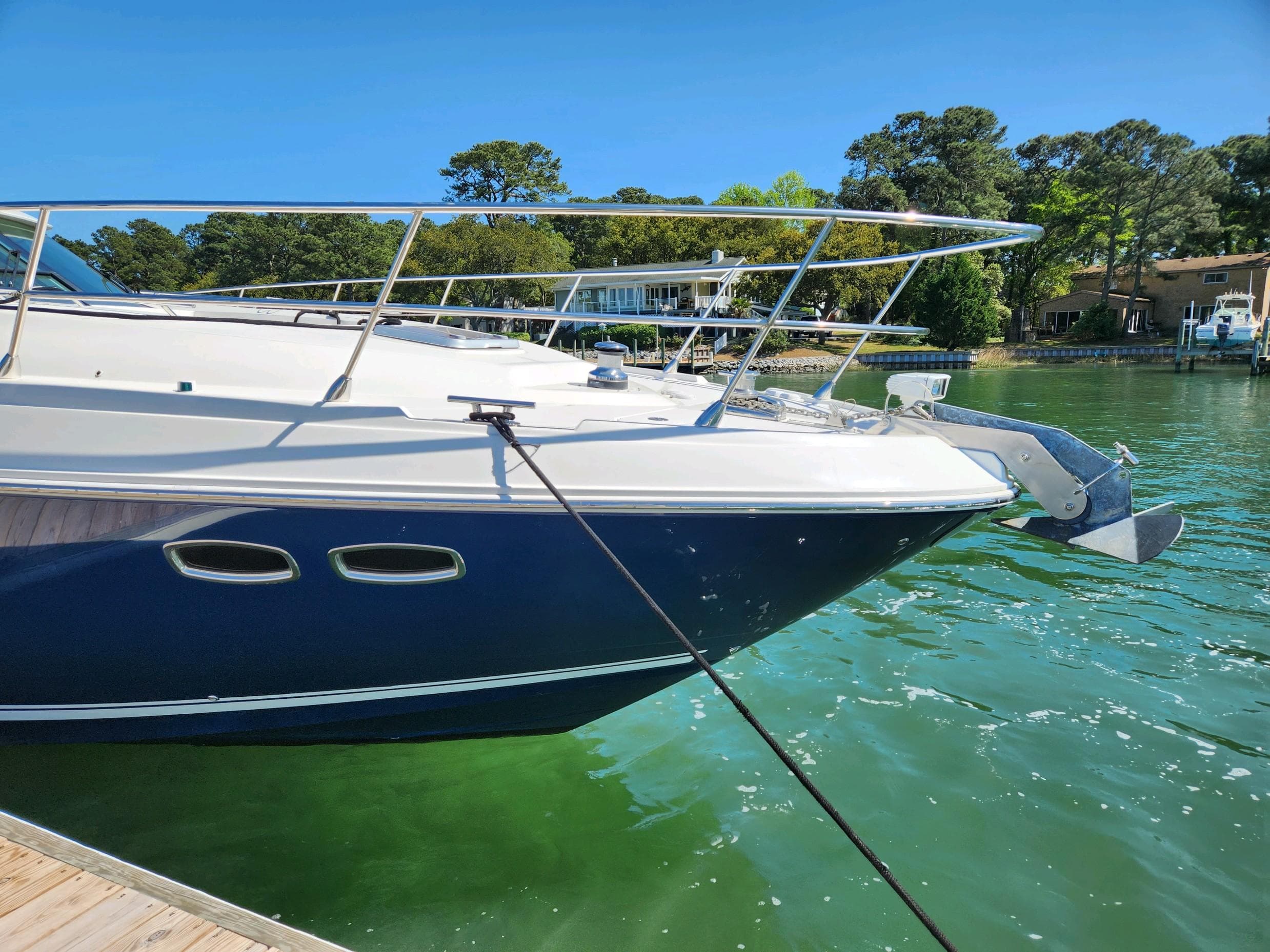 2011 Sea Ray 540 Sundancer yacht docked on a sunny day, surrounded by greenery.