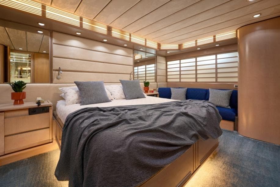 Luxurious bedroom interior of 1992 Posillipo Technema 82 yacht with modern design and cozy ambiance.