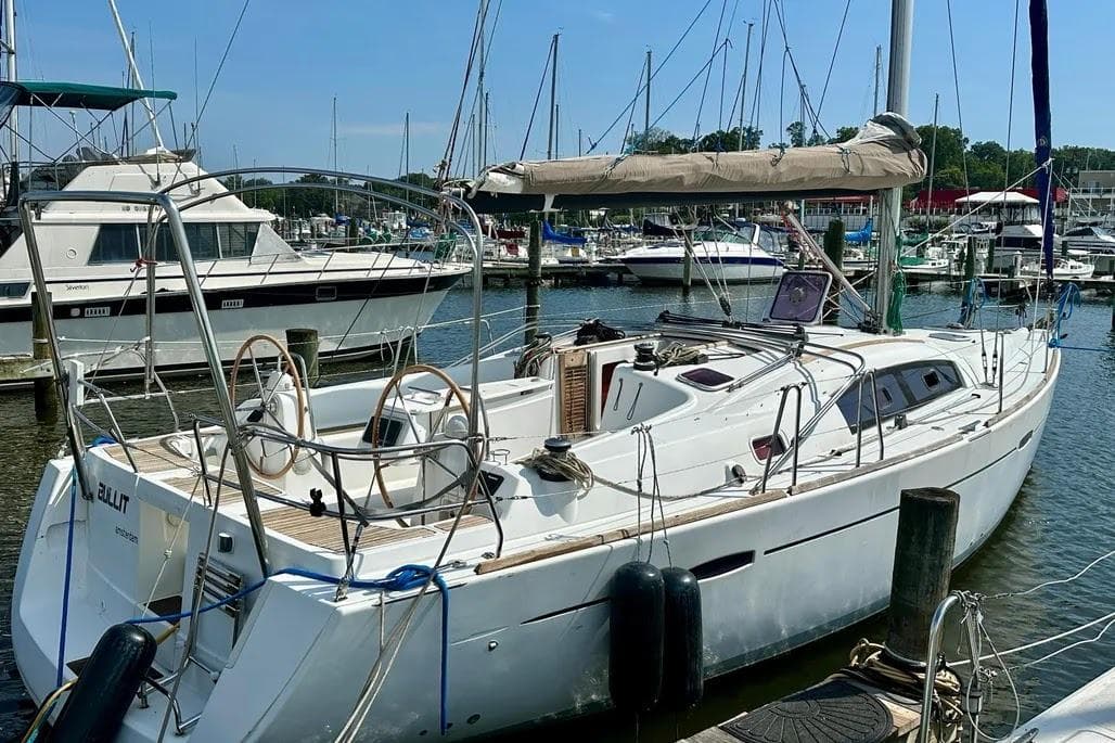 2011 Beneteau Oceanis 40 sailboat docked in a marina, featuring dual steering wheels.