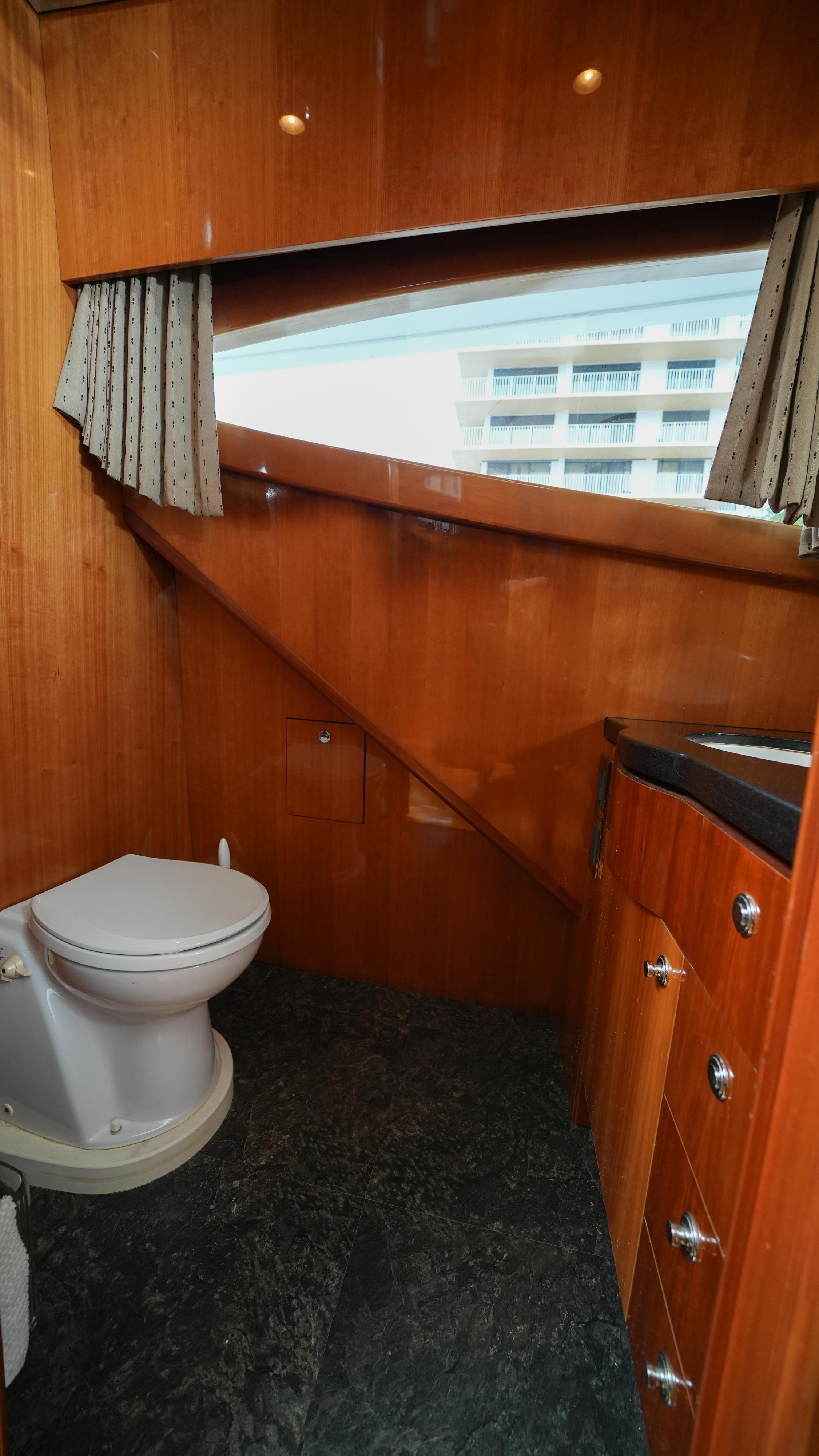 2002 Queenship 70 Baretta yacht bathroom with wooden cabinetry and modern fixtures.
