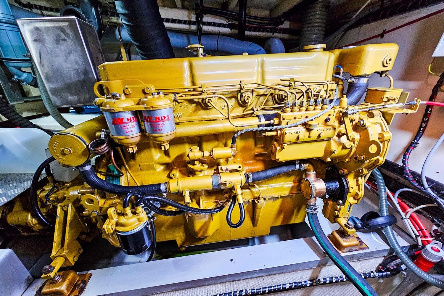 Engine room of a 1980 Grand Banks 42 Europa, featuring a yellow marine engine.