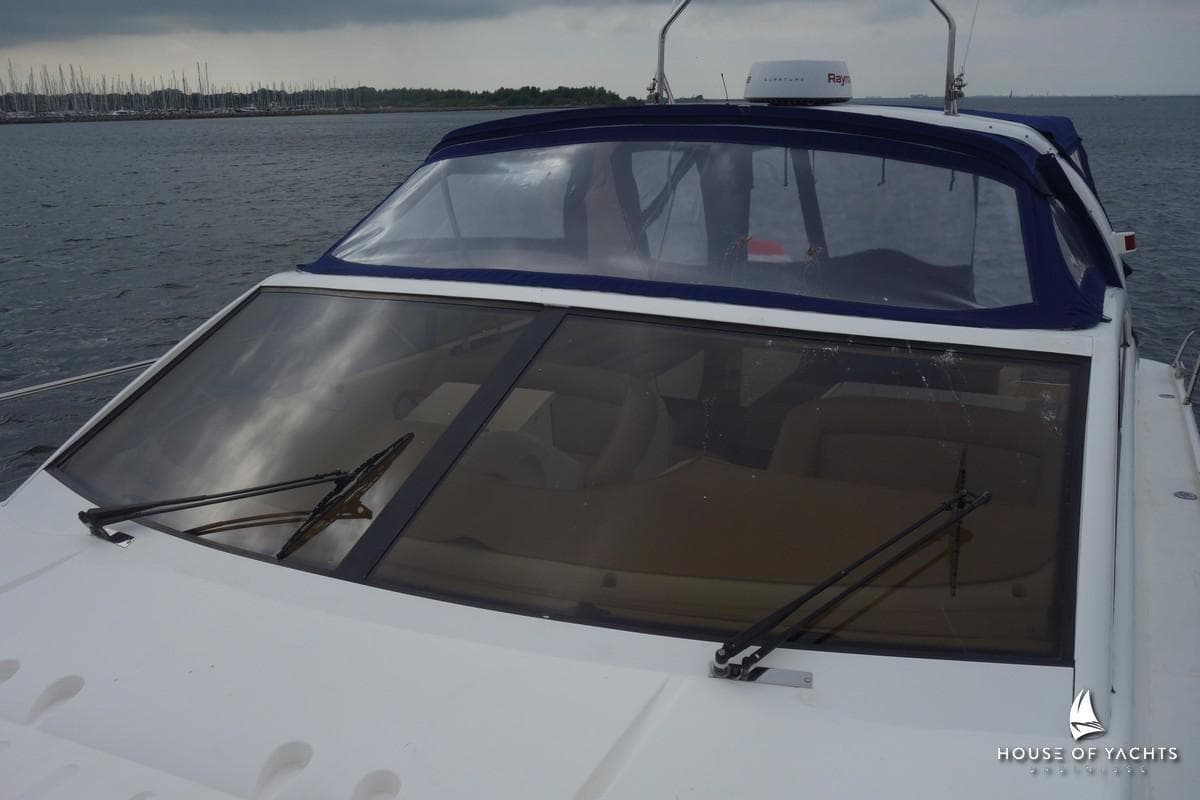 1996 Princess V52 yacht with blue canopy, docked on a calm sea.