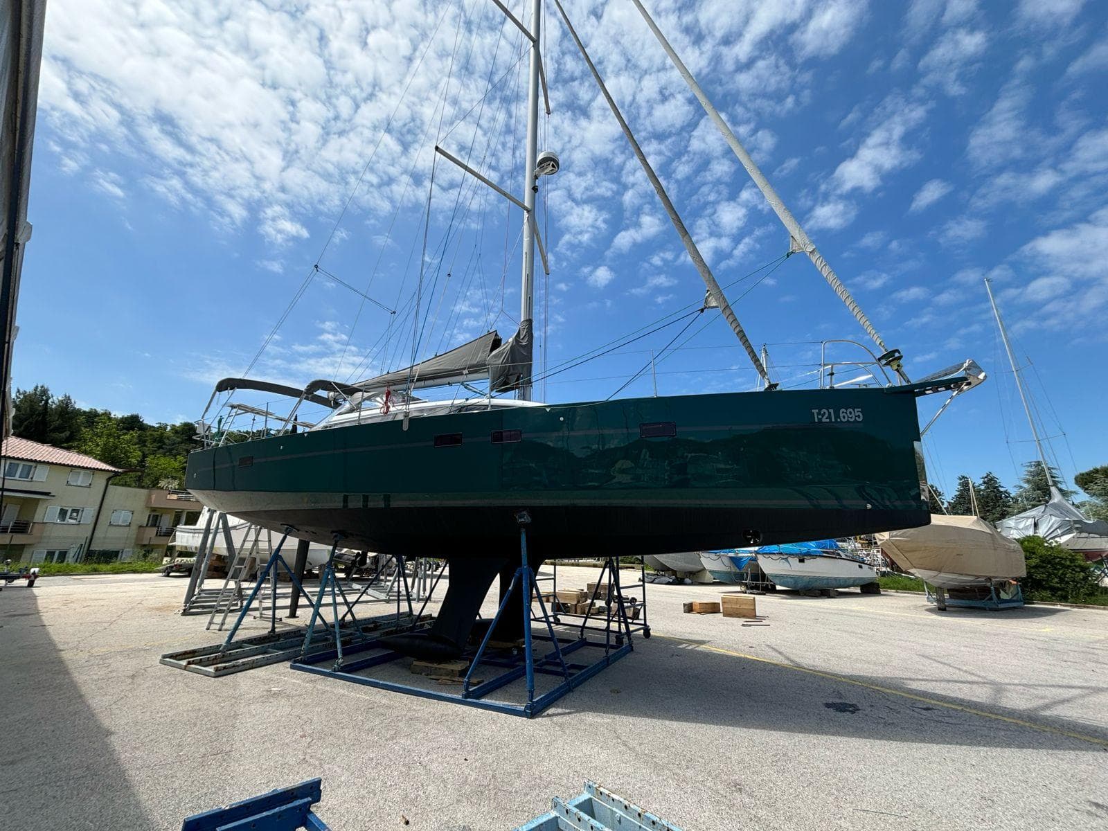 2012 RM Yachts 1260 sailboat on stands under a blue sky.