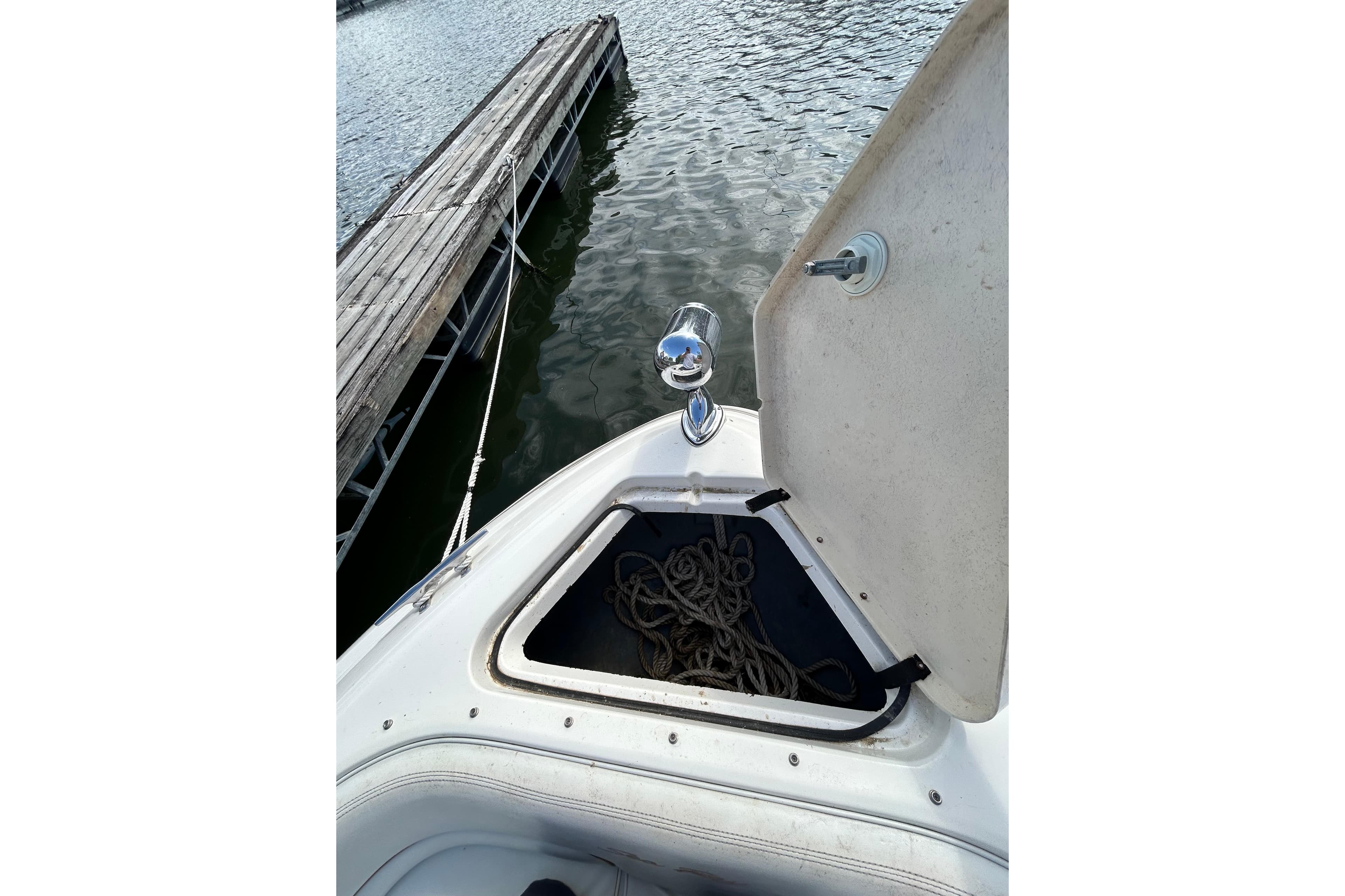 Open storage compartment on 1998 Sea Ray 280 Bow Rider boat, dockside view.