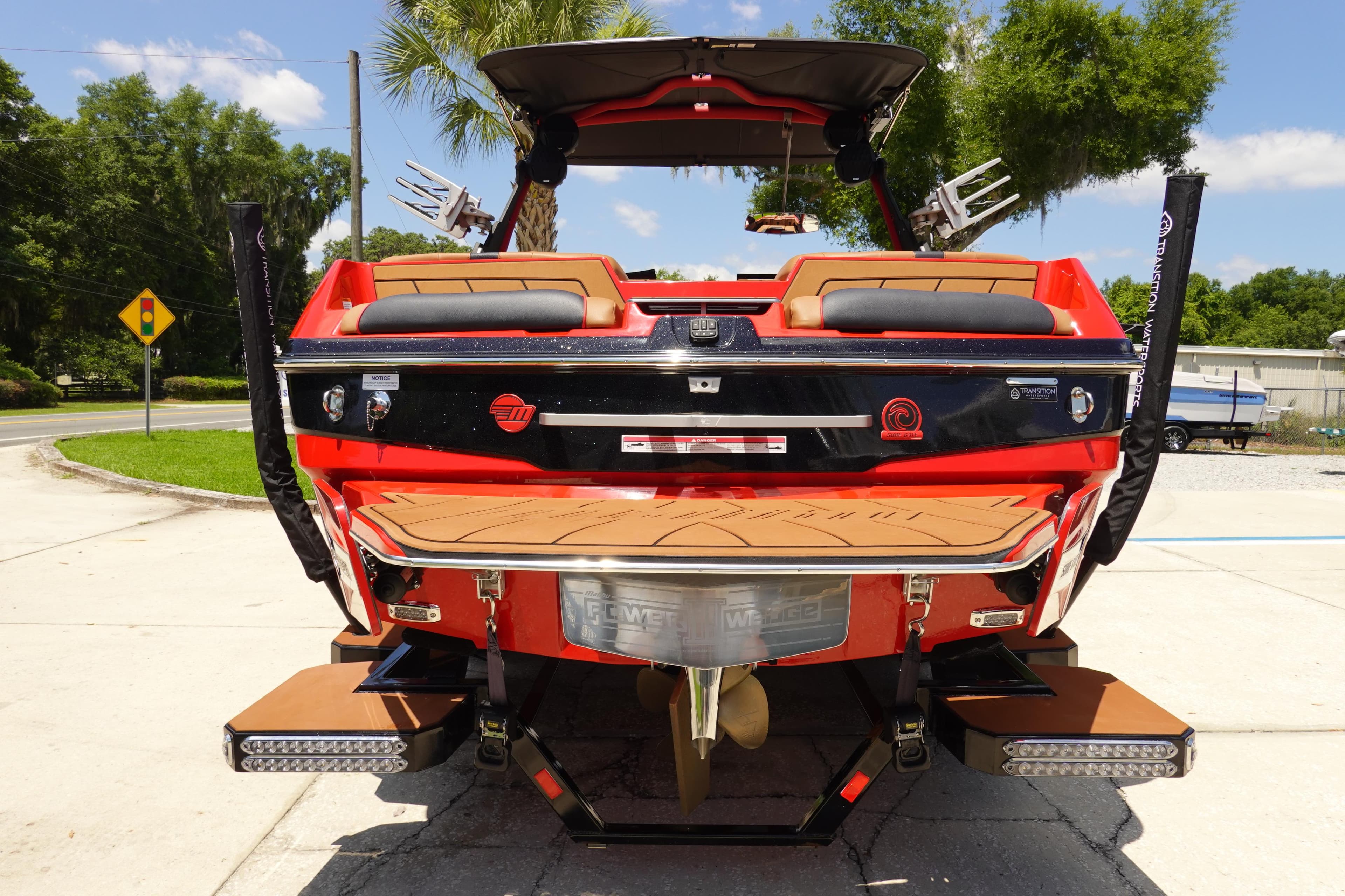 2023 Malibu 23 LSV boat rear view with swim platform and wakeboard racks.