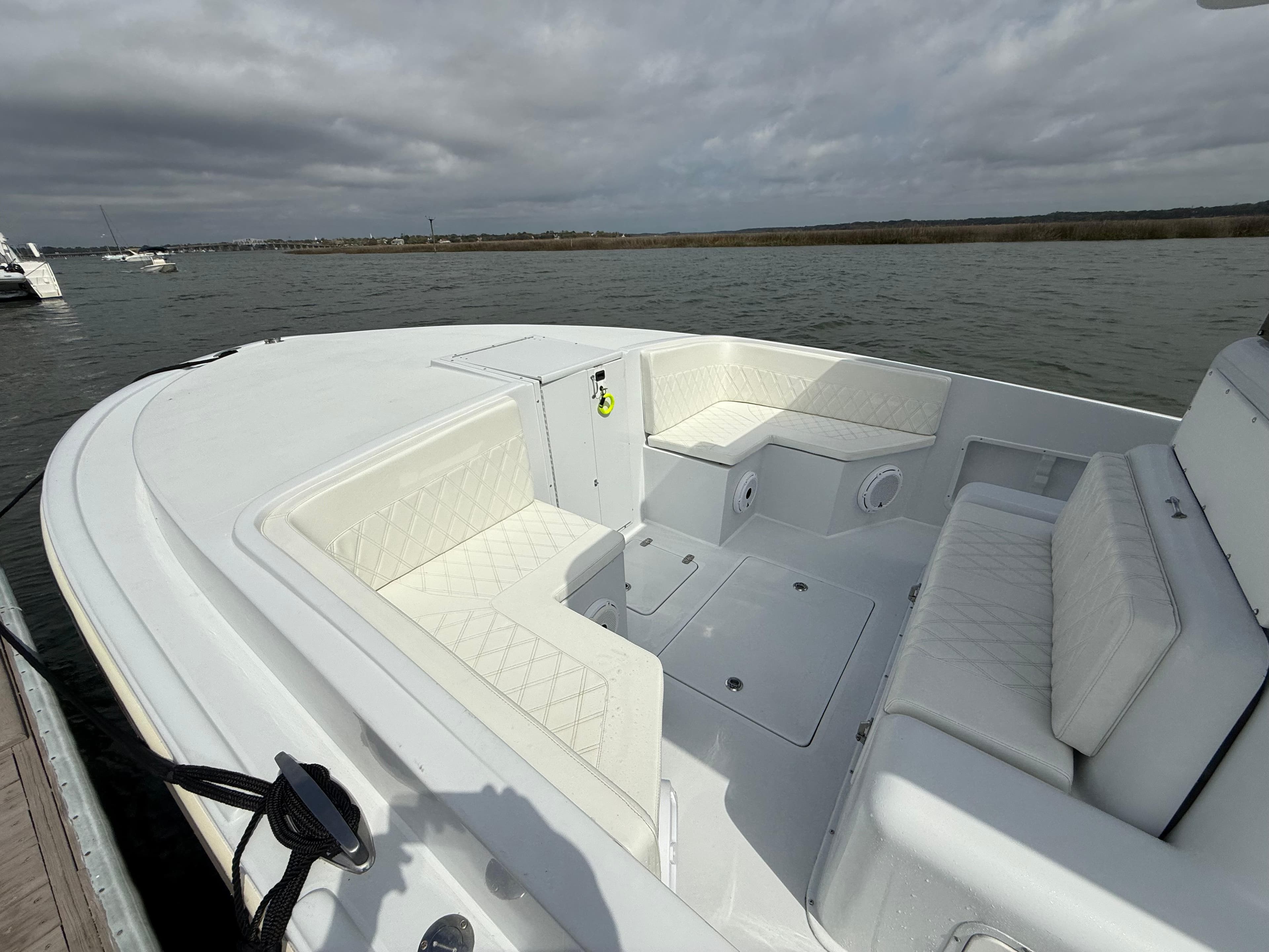 2003 Strike 35 Cuddy boat with white seating, docked on a cloudy day.