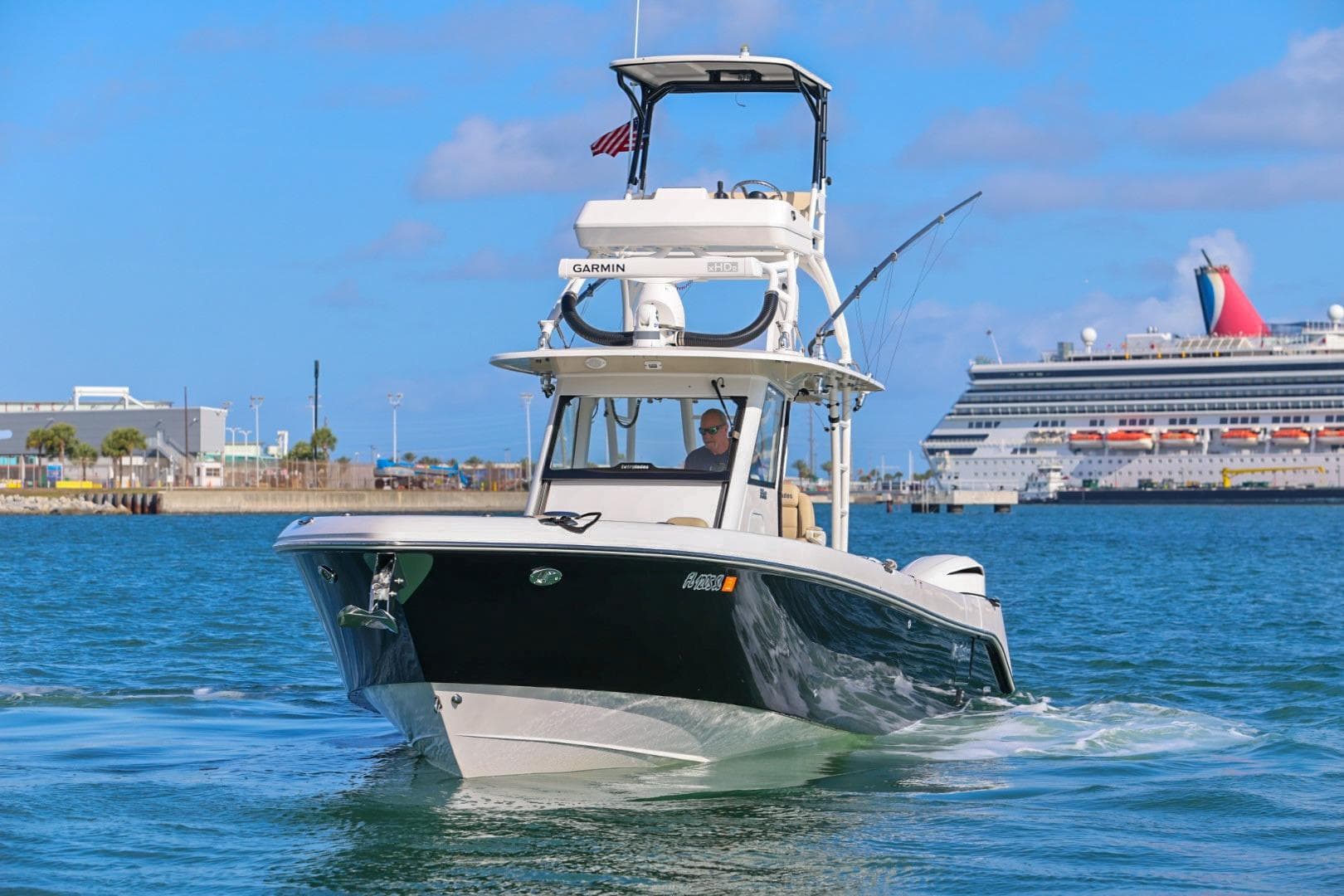 2017 Everglades 355 Center Console boat cruising near a large cruise ship.