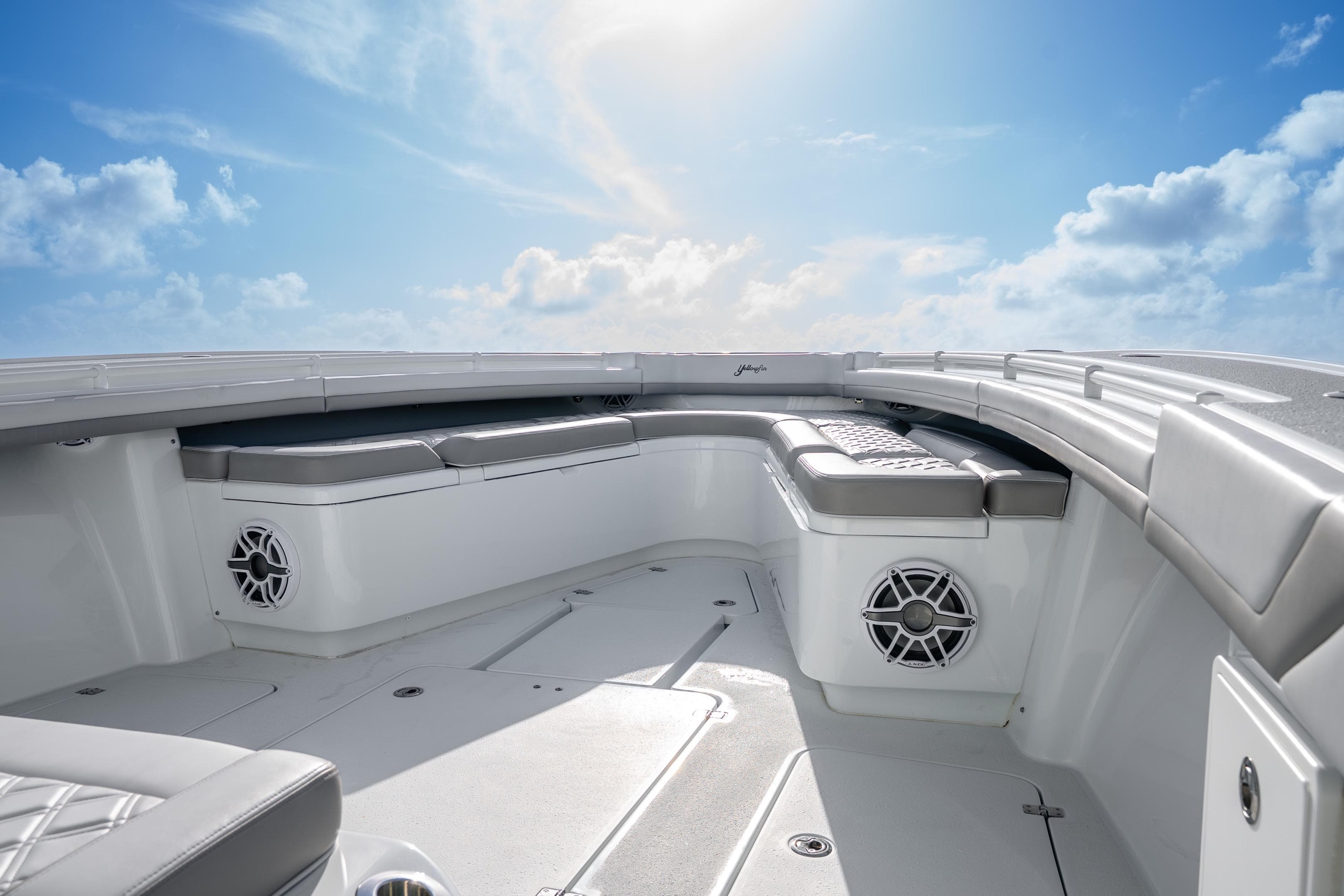 2024 Yellowfin 39 Offshore boat interior with cushioned seating under a clear blue sky.